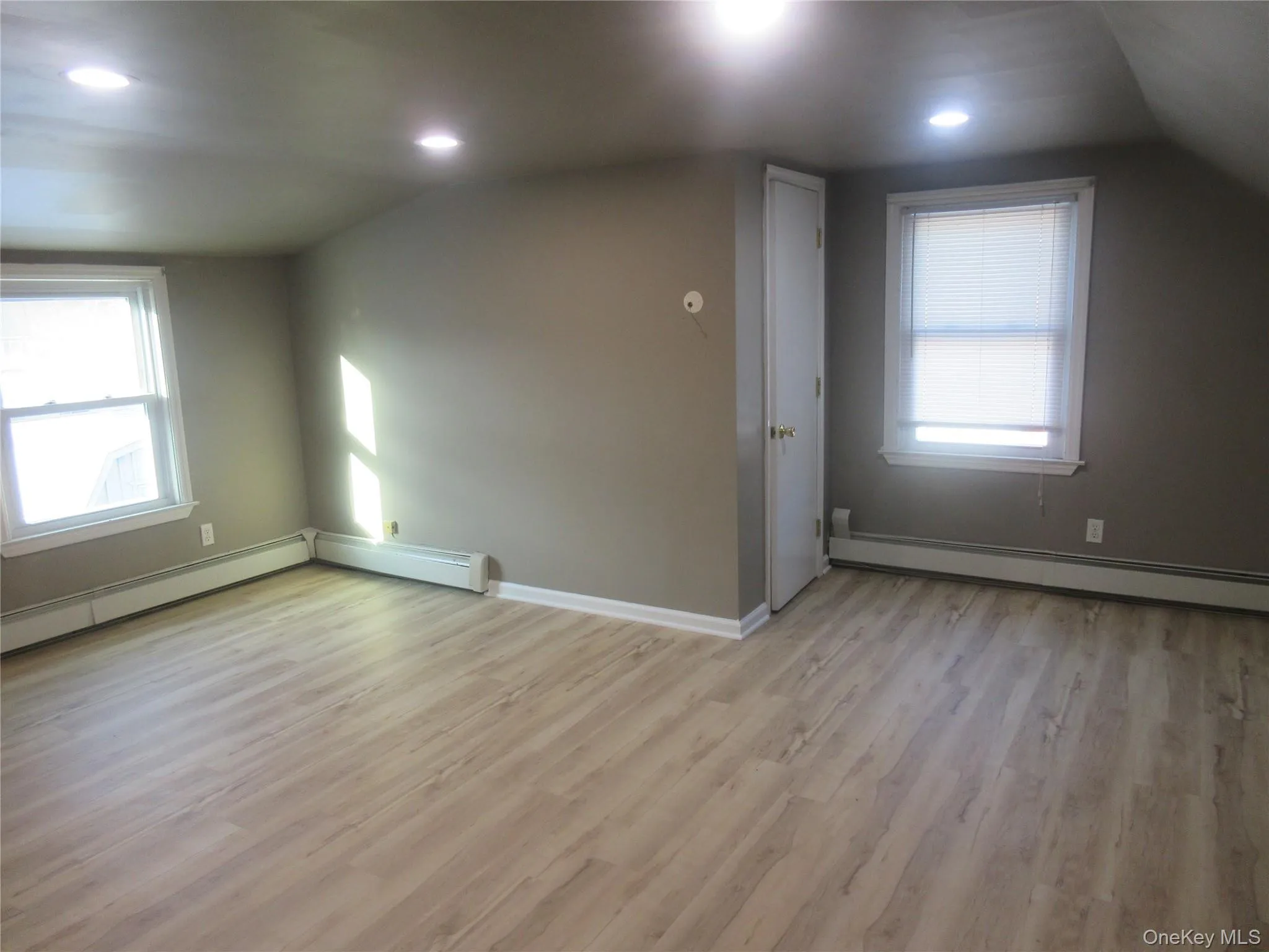 Bonus room featuring light wood-style floors, vaulted ceiling, a baseboard radiator, and recessed lighting Bonus room featuring light wood-style floors, vaulted ceiling, a baseboard radiator, and recessed lighting