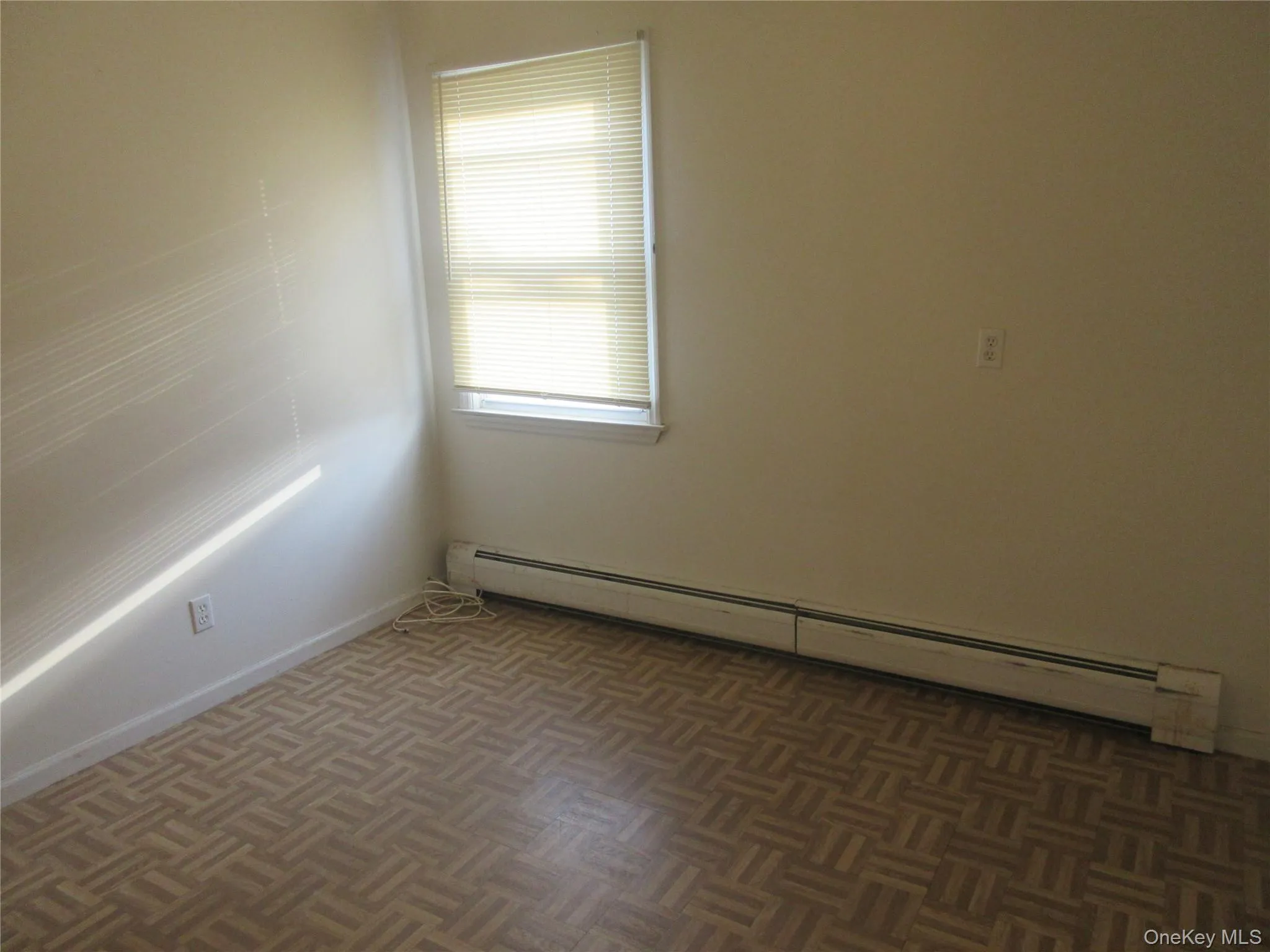 Spare room with a baseboard radiator and baseboards Spare room with a baseboard radiator and baseboards