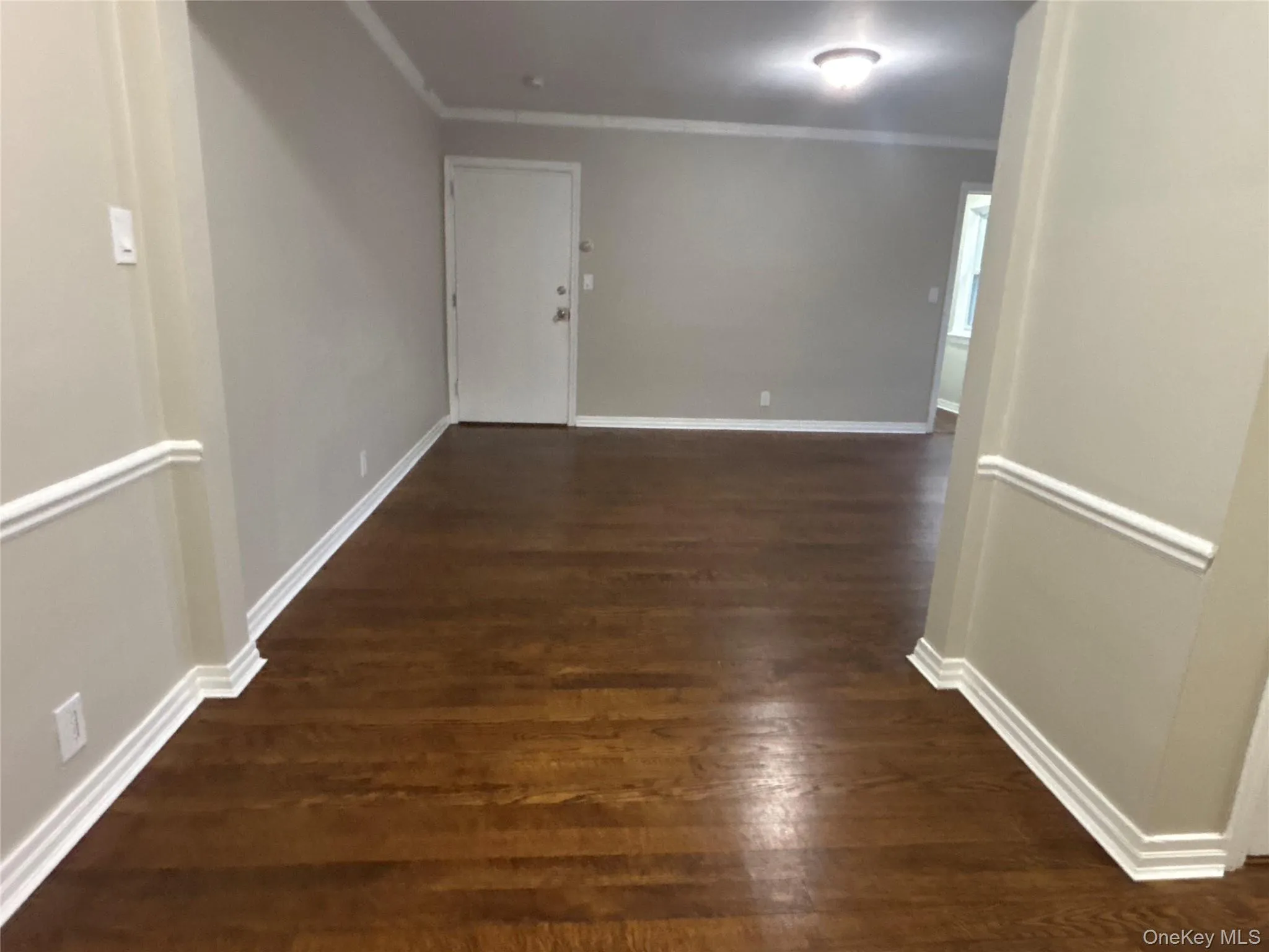 Corridor featuring dark wood-style flooring and crown molding Corridor featuring dark wood-style flooring and crown molding