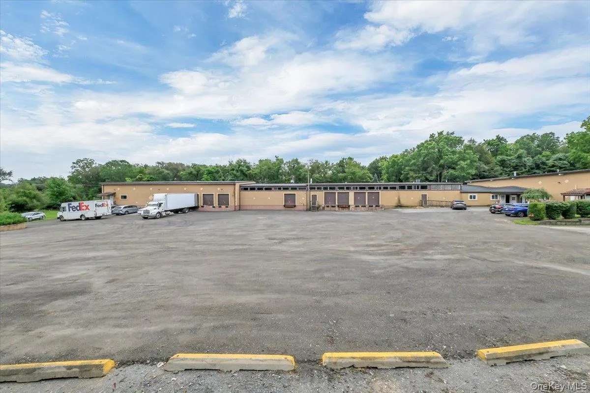 Uncovered parking lot featuring view of scattered trees Uncovered parking lot featuring view of scattered trees