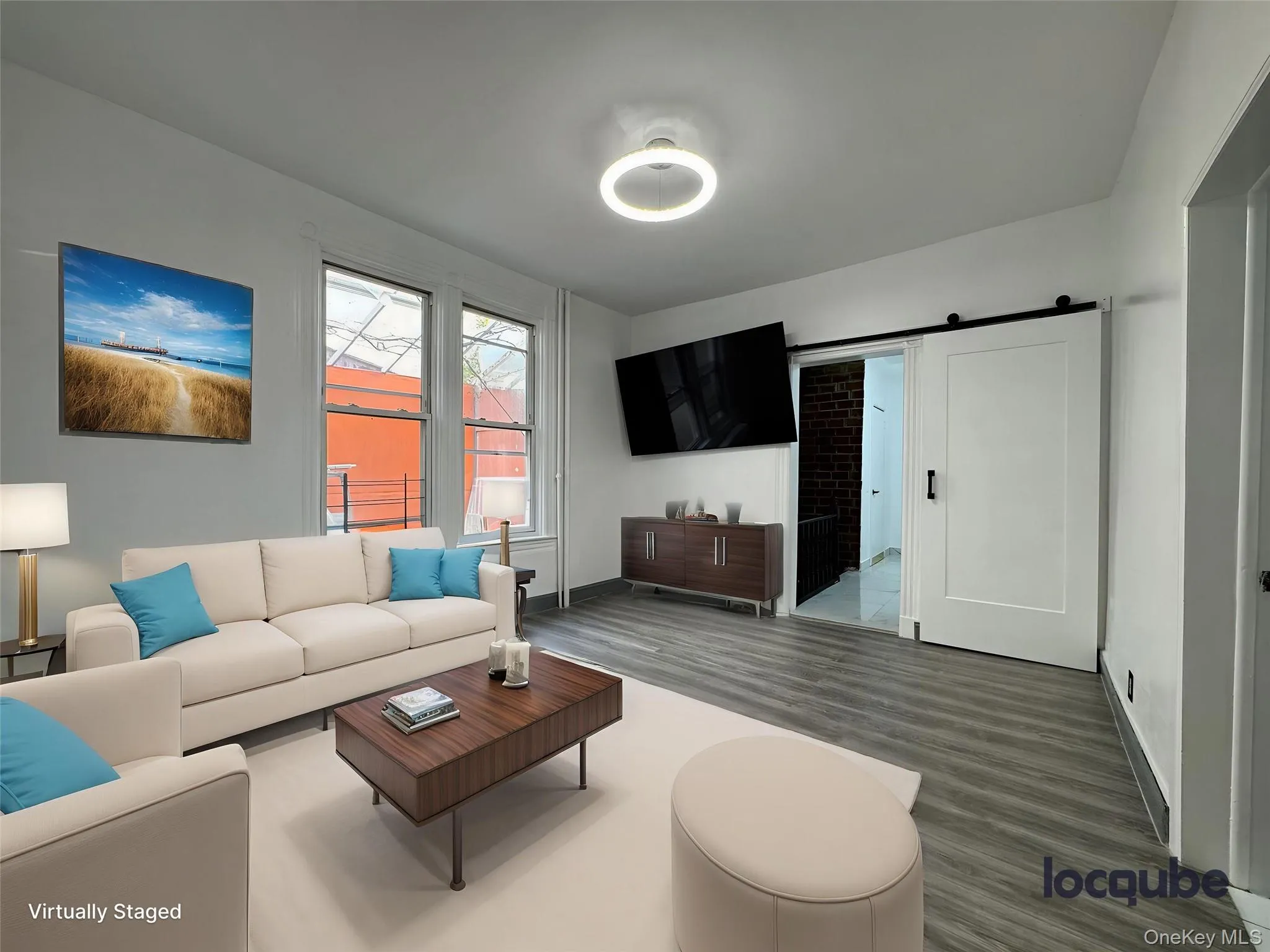 Living area with a barn door and wood finished floors Living area with a barn door and wood finished floors