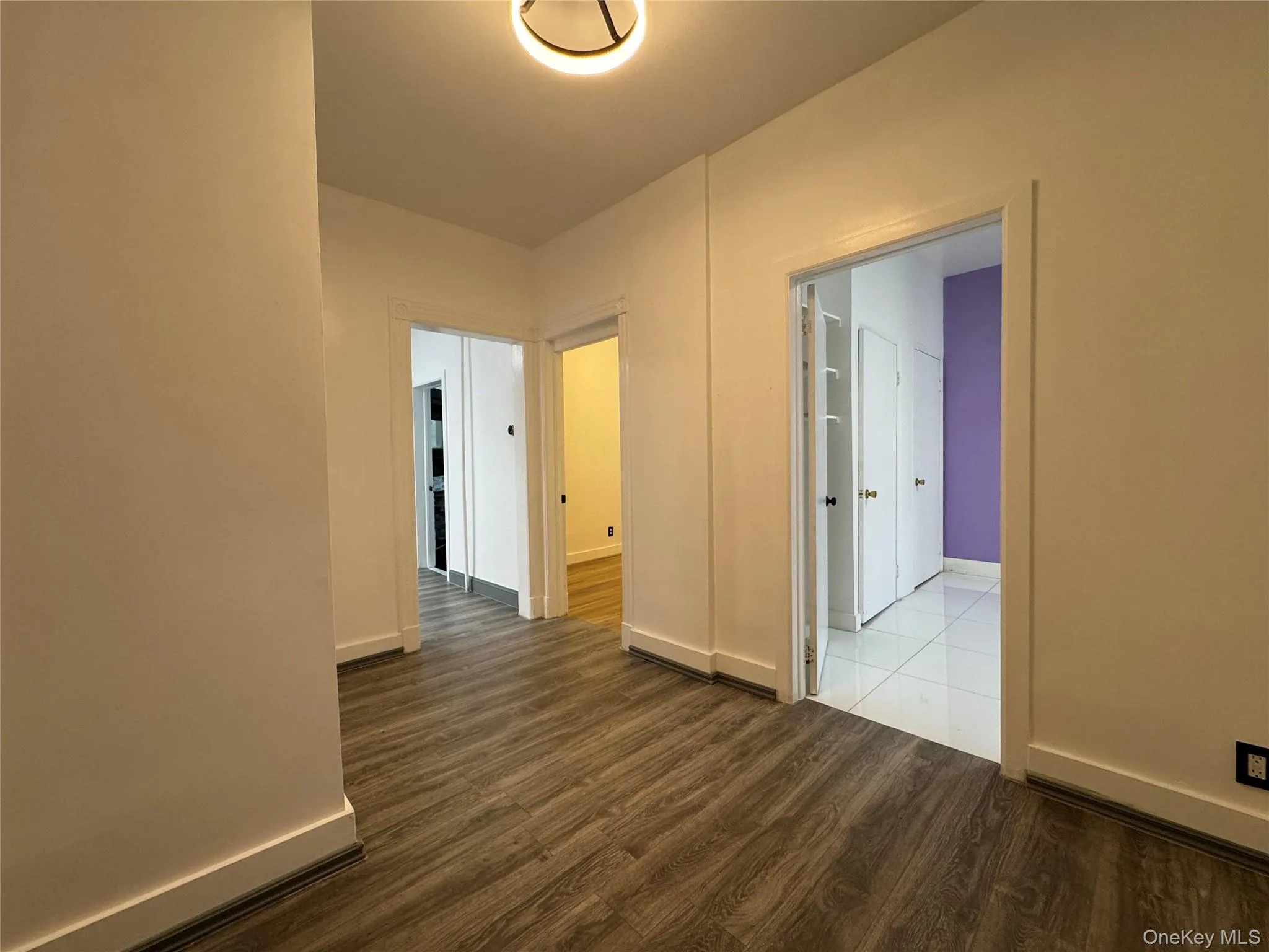 Empty room featuring dark wood-style floors and baseboards Empty room featuring dark wood-style floors and baseboards