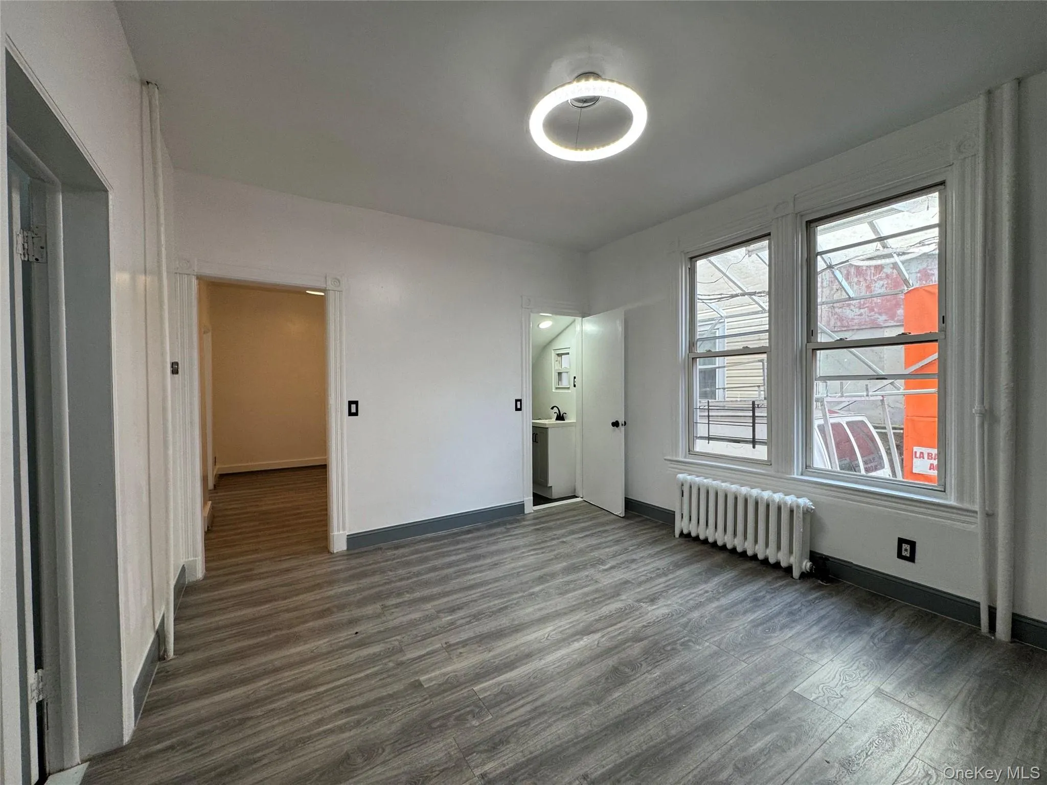 Spare room featuring dark wood-style floors and radiator Spare room featuring dark wood-style floors and radiator