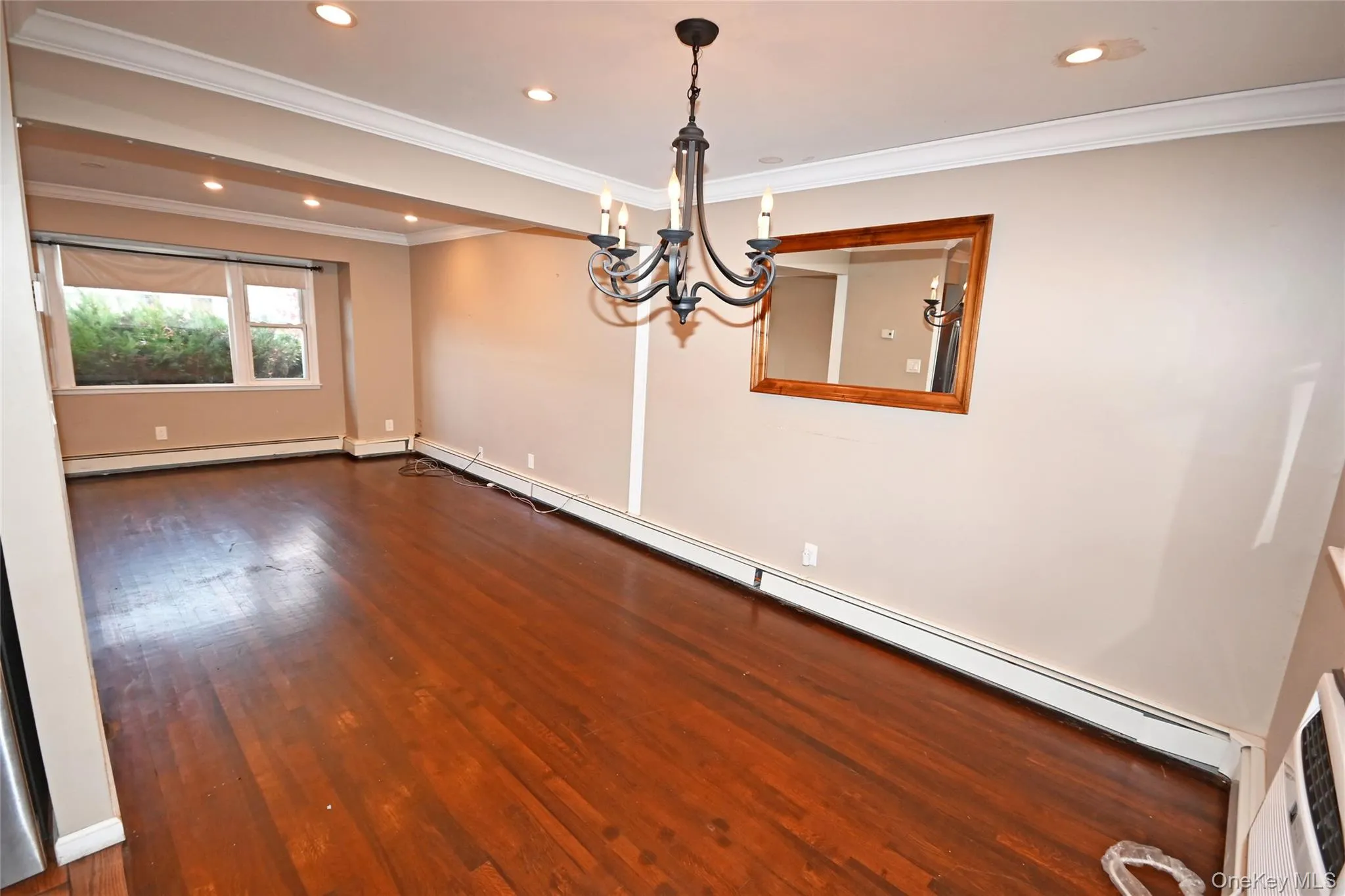 Unfurnished room featuring dark wood finished floors, a baseboard heating unit, crown molding, recessed lighting, and a chandelier Unfurnished room featuring dark wood finished floors, a baseboard heating unit, crown molding, recessed lighting, and a chandelier
