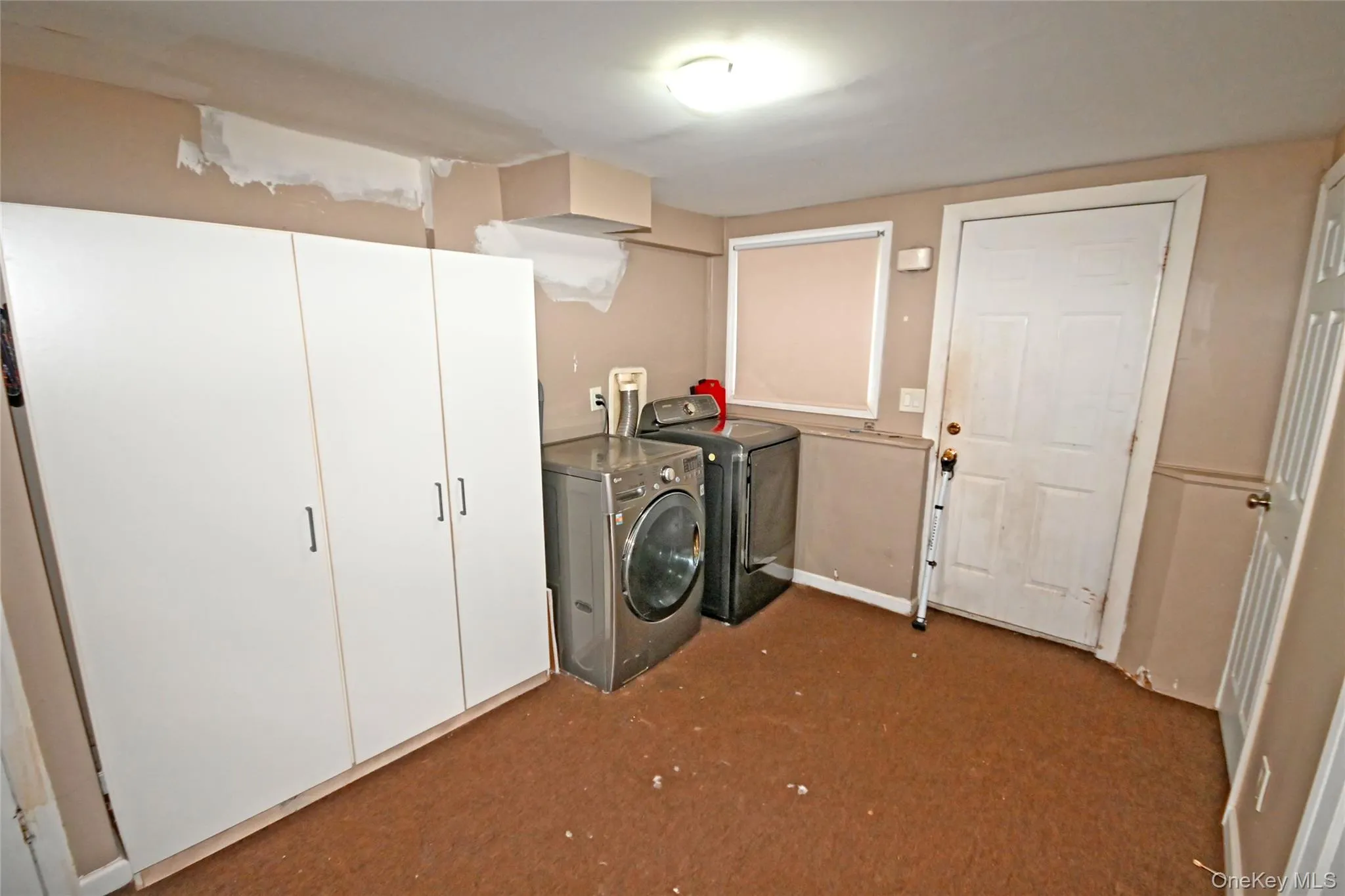 Laundry area featuring dark carpet and washing machine and clothes dryer Laundry area featuring dark carpet and washing machine and clothes dryer