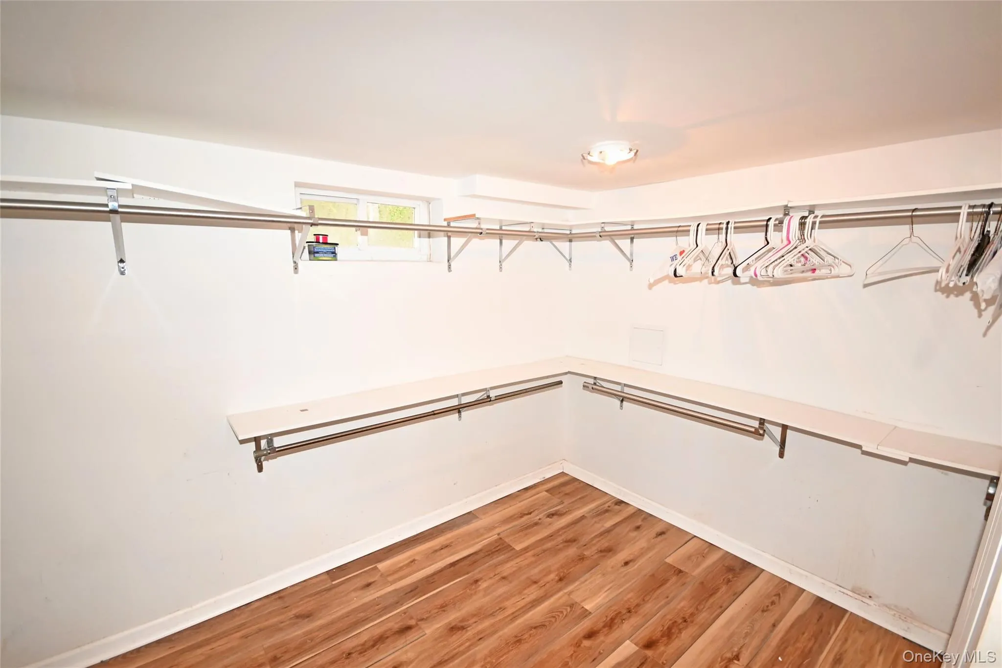 Spacious closet with light wood-style flooring Spacious closet with light wood-style flooring