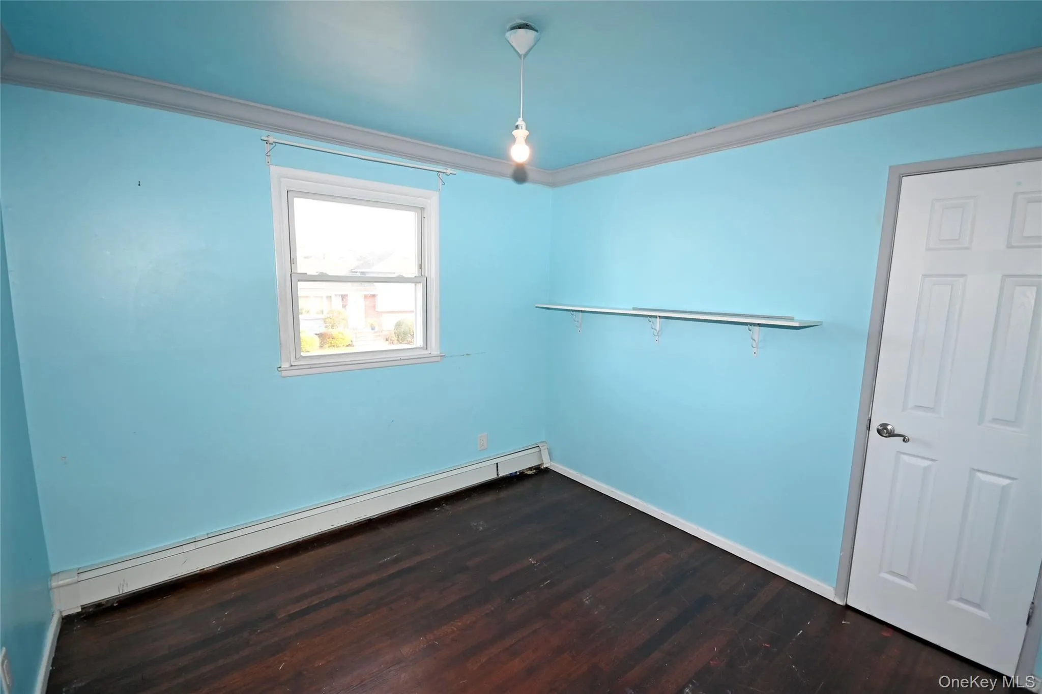 Unfurnished room with crown molding, a baseboard radiator, and dark wood-style floors Unfurnished room with crown molding, a baseboard radiator, and dark wood-style floors