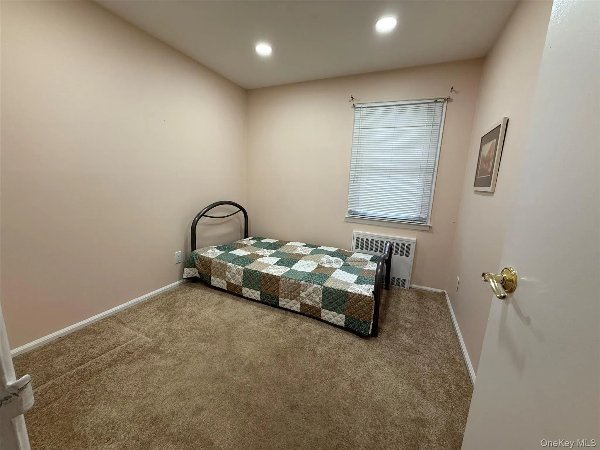 Carpeted bedroom featuring radiator and recessed lighting Carpeted bedroom featuring radiator and recessed lighting