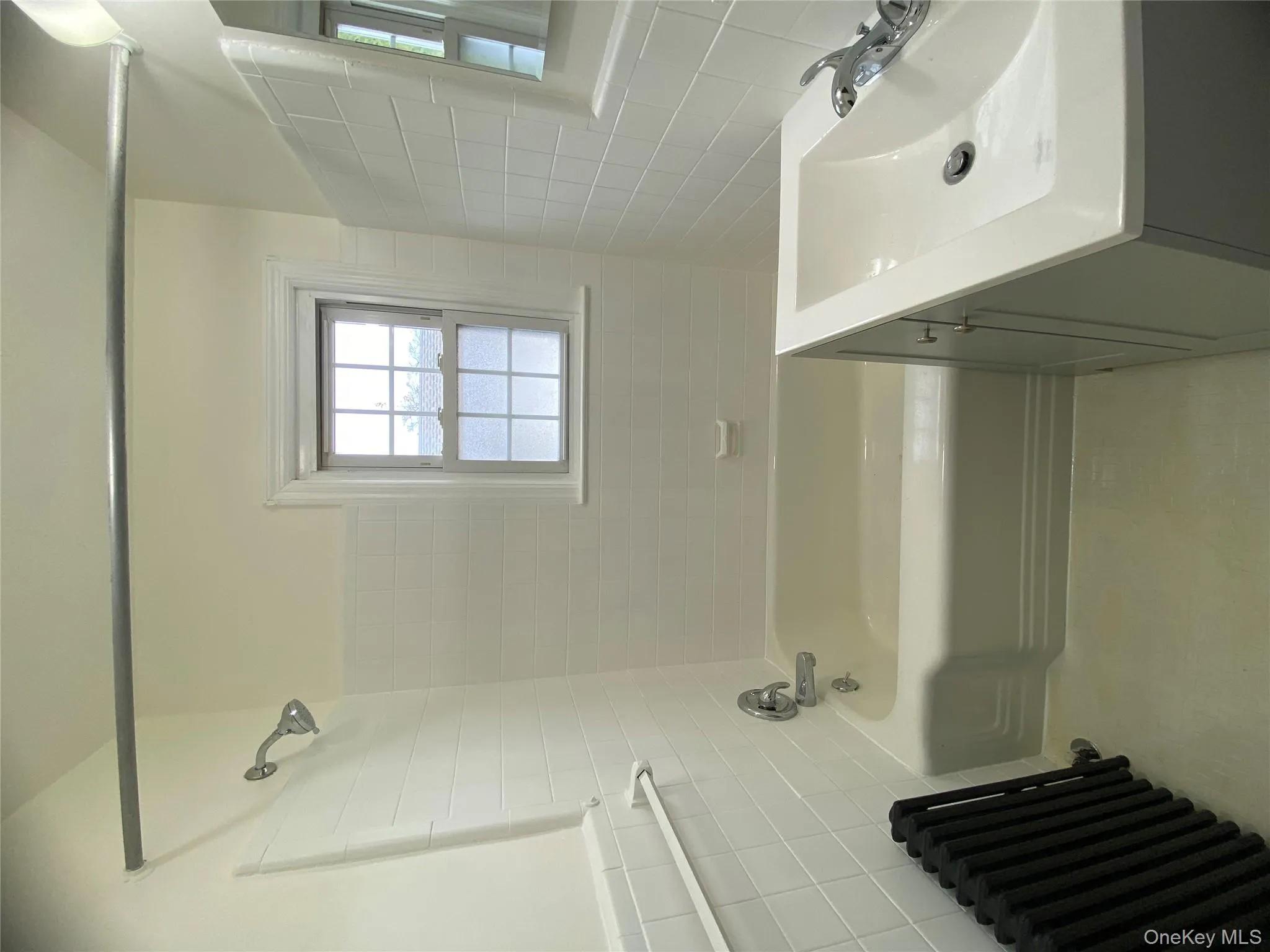 Full bath with tile walls, radiator heating unit, bathing tub / shower combination, and vanity Full bath with tile walls, radiator heating unit, bathing tub / shower combination, and vanity