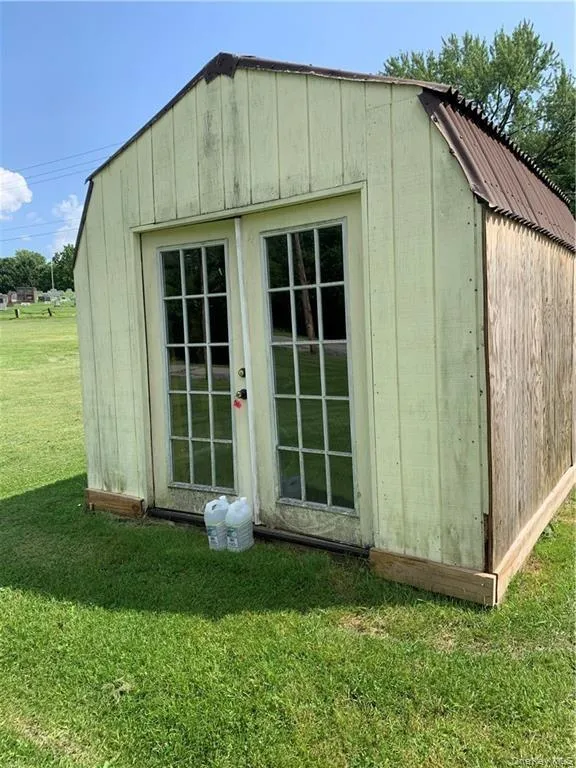 View of outdoor structure with a lawn View of outdoor structure with a lawn