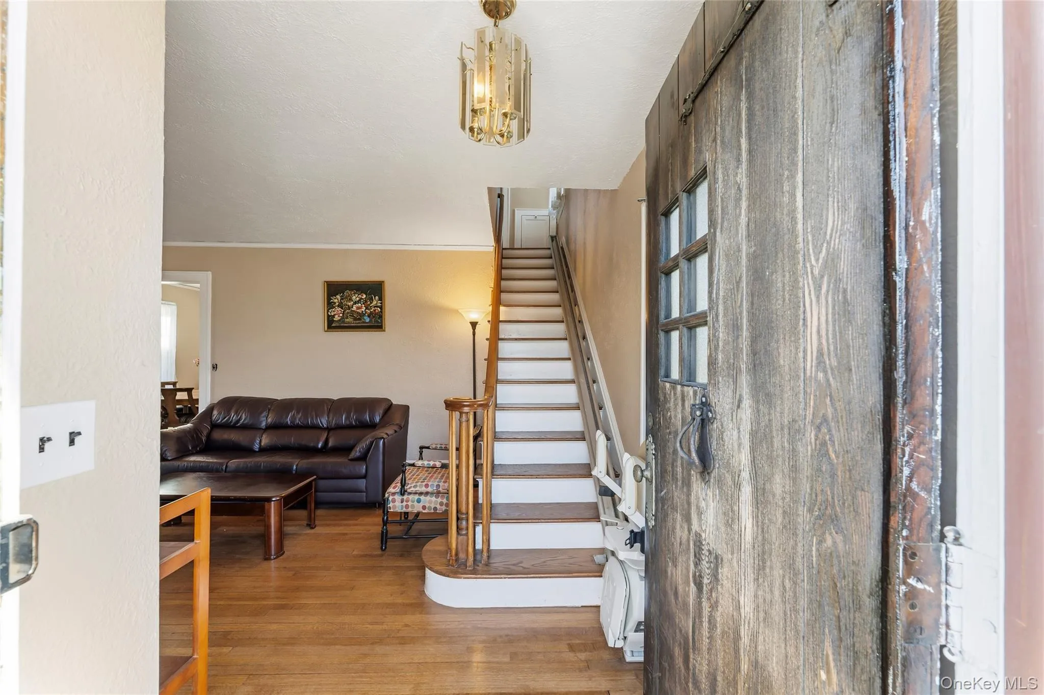 Entrance foyer with light wood-type flooring, stairway, a chandelier, and ornamental molding Entrance foyer with light wood-type flooring, stairway, a chandelier, and ornamental molding