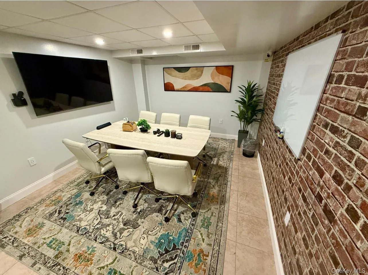 Dining room with brick wall, tile patterned floors, recessed lighting, and a paneled ceiling Dining room with brick wall, tile patterned floors, recessed lighting, and a paneled ceiling