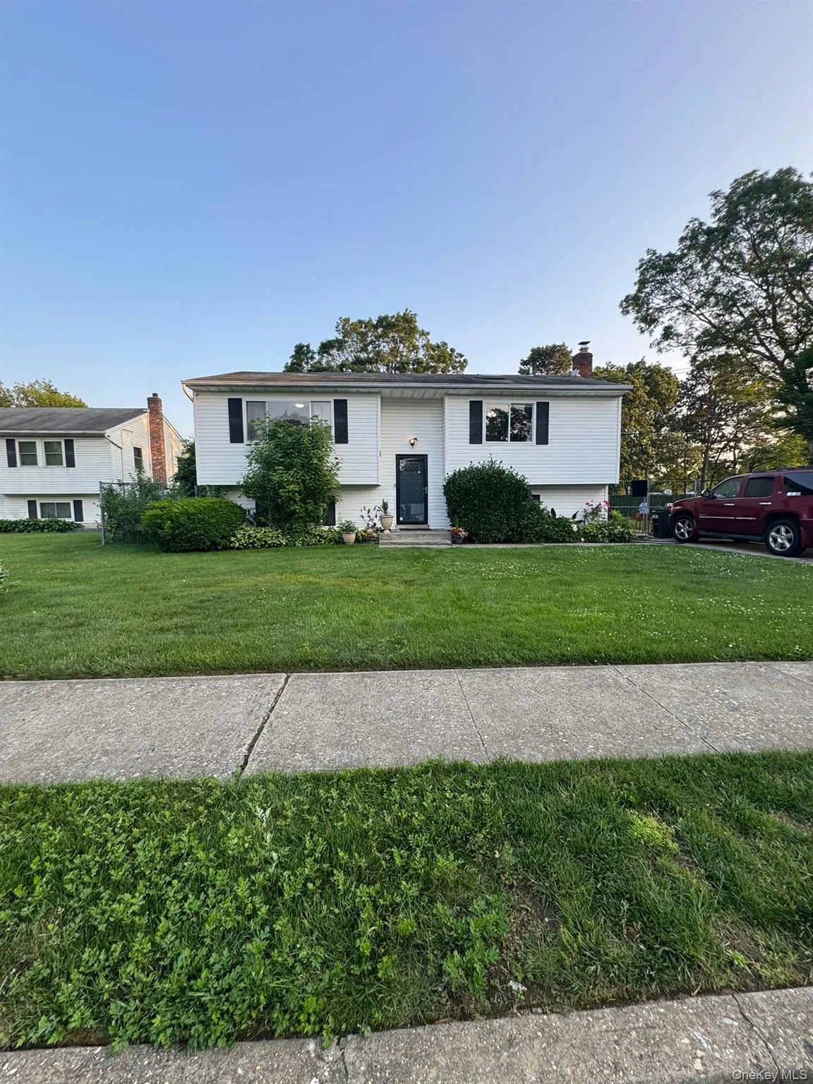 Raised ranch featuring a front yard and a chimney Raised ranch featuring a front yard and a chimney