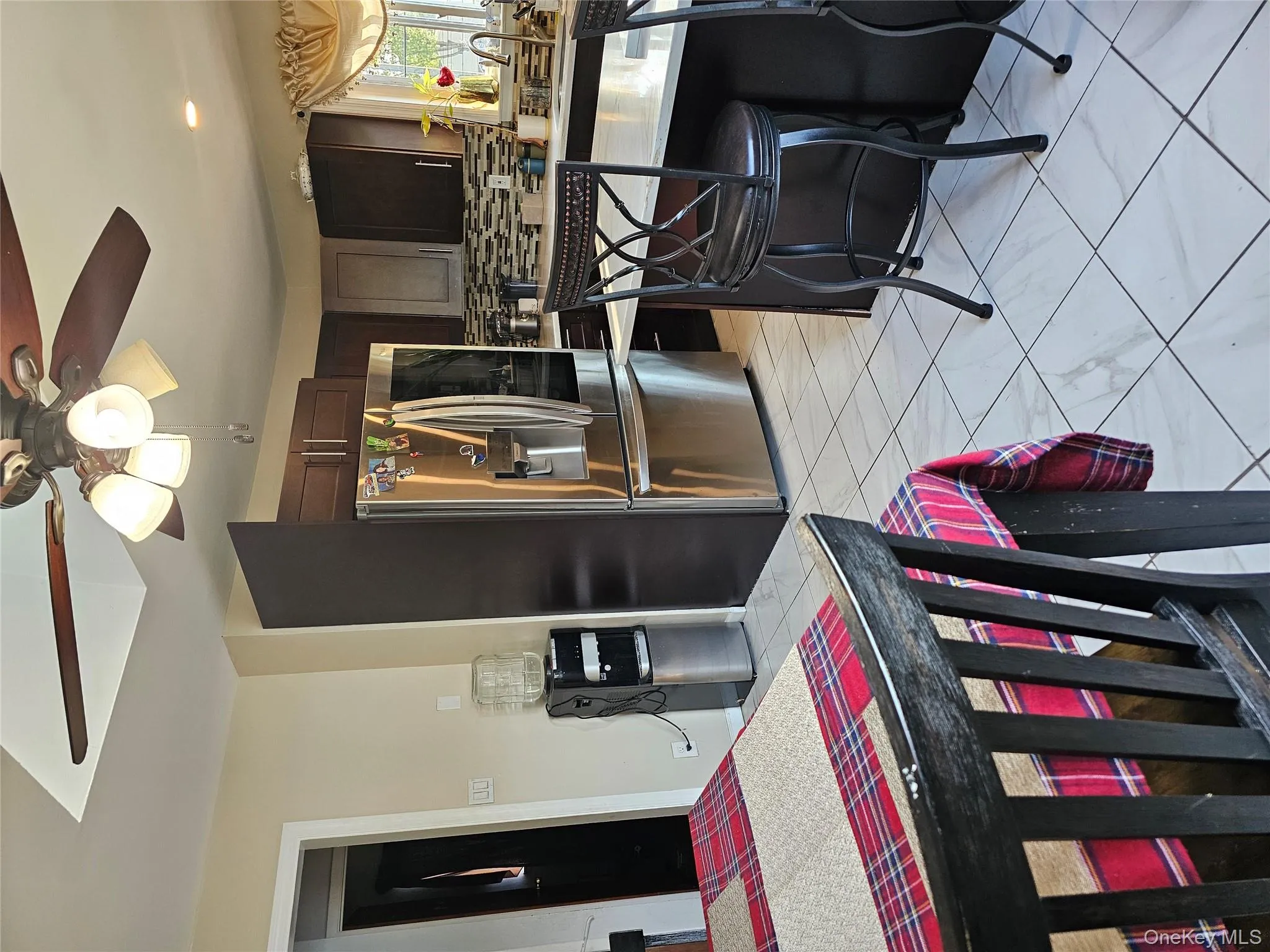 Kitchen featuring refrigerator, light countertops, ceiling fan, and dark brown cabinetry Kitchen featuring refrigerator, light countertops, ceiling fan, and dark brown cabinetry