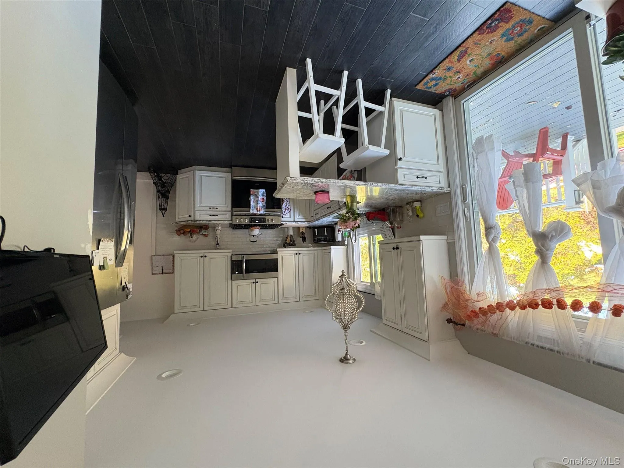 Kitchen with range, white cabinets, decorative backsplash, a peninsula, and light stone countertops Kitchen with range, white cabinets, decorative backsplash, a peninsula, and light stone countertops