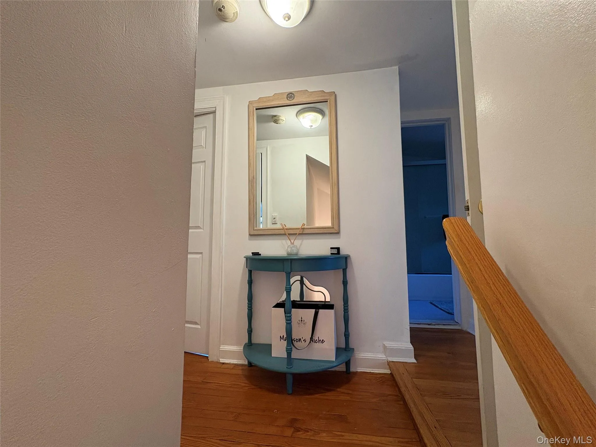 Hallway with a textured wall and dark wood finished floors Hallway with a textured wall and dark wood finished floors