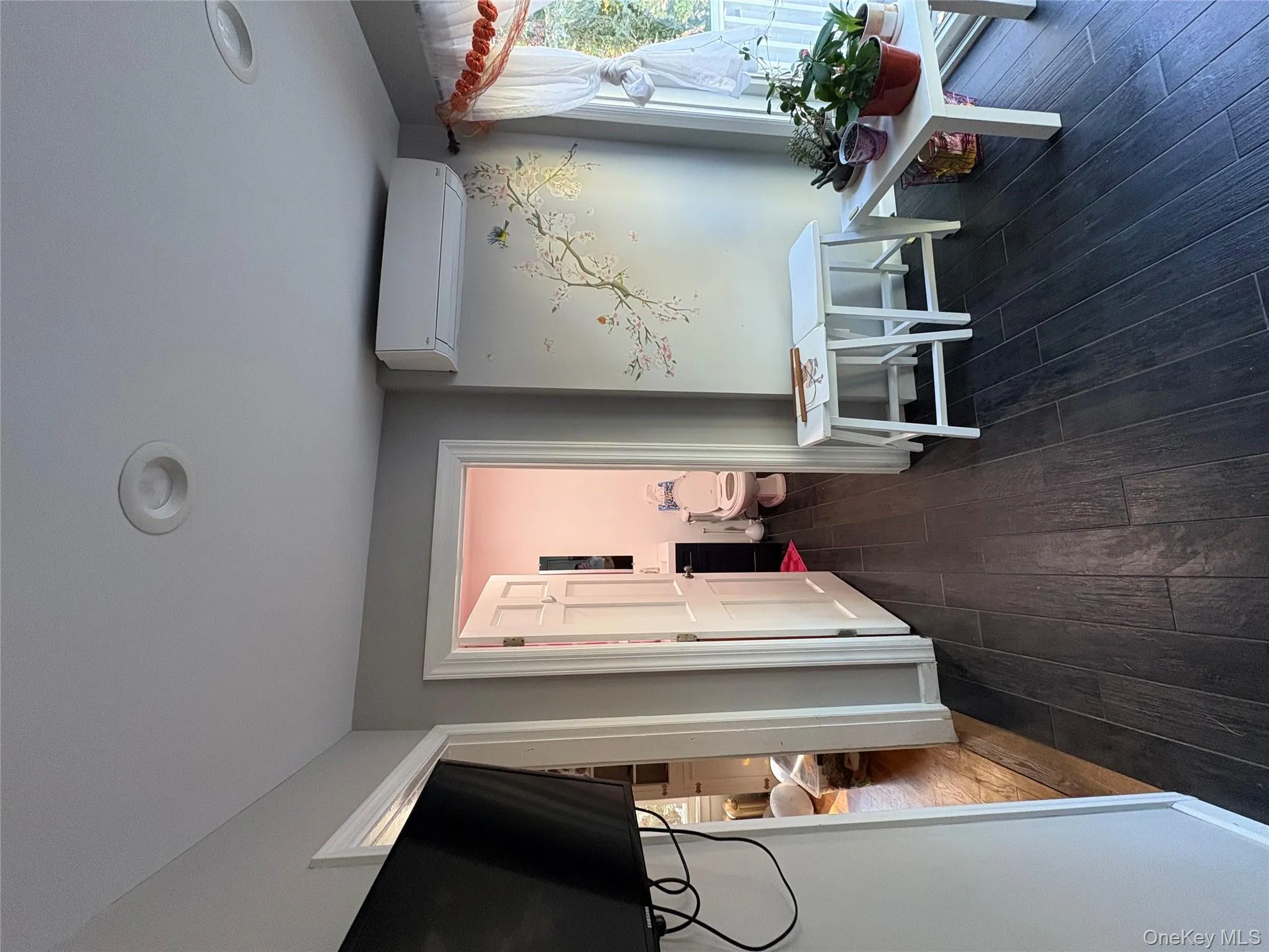 Corridor with dark wood finished floors and an AC wall unit Corridor with dark wood finished floors and an AC wall unit