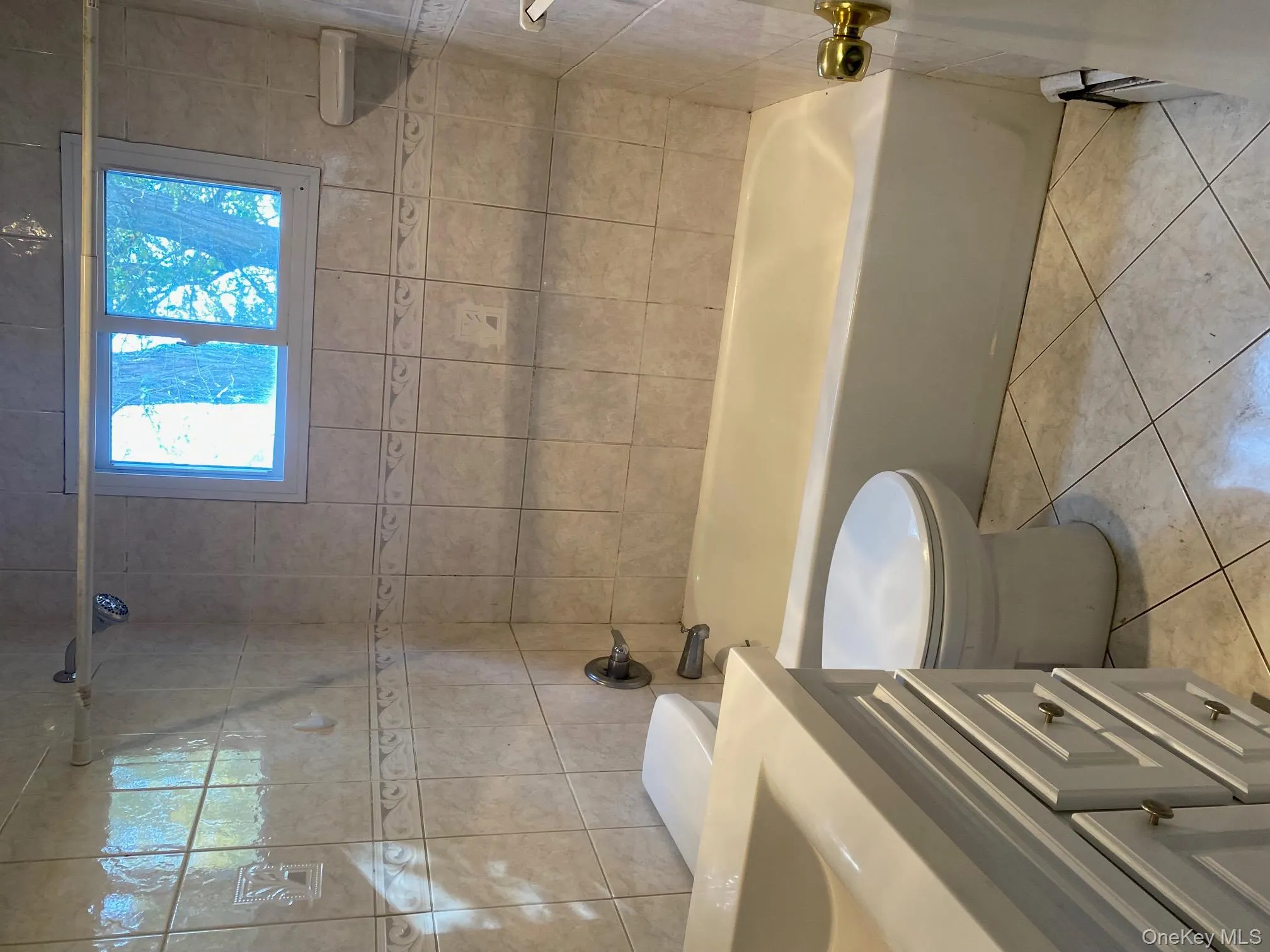 Bathroom with bathtub / shower combination, vanity, and light tile patterned floors Bathroom with bathtub / shower combination, vanity, and light tile patterned floors