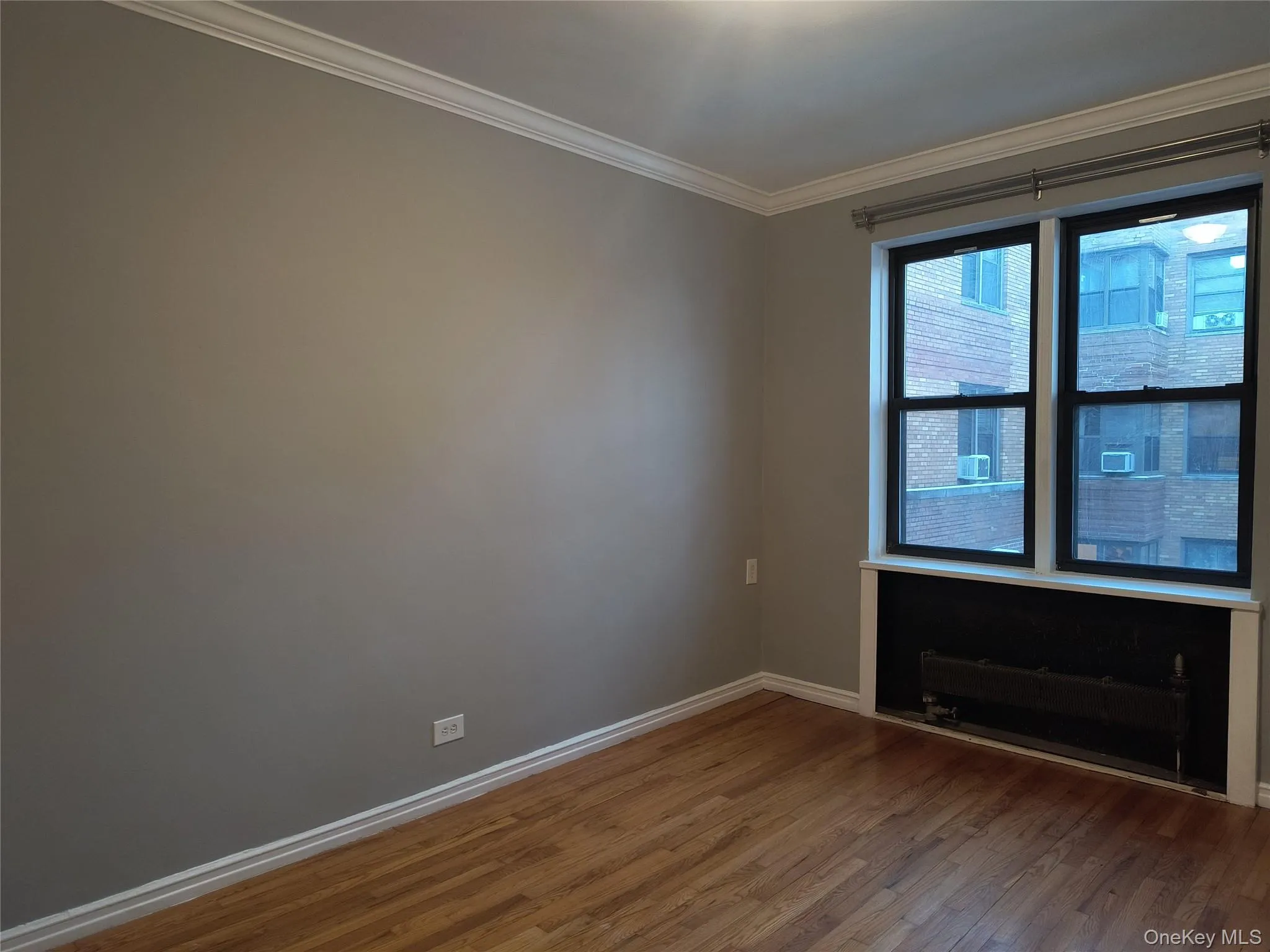 Empty room with crown molding and dark wood-style floors Empty room with crown molding and dark wood-style floors