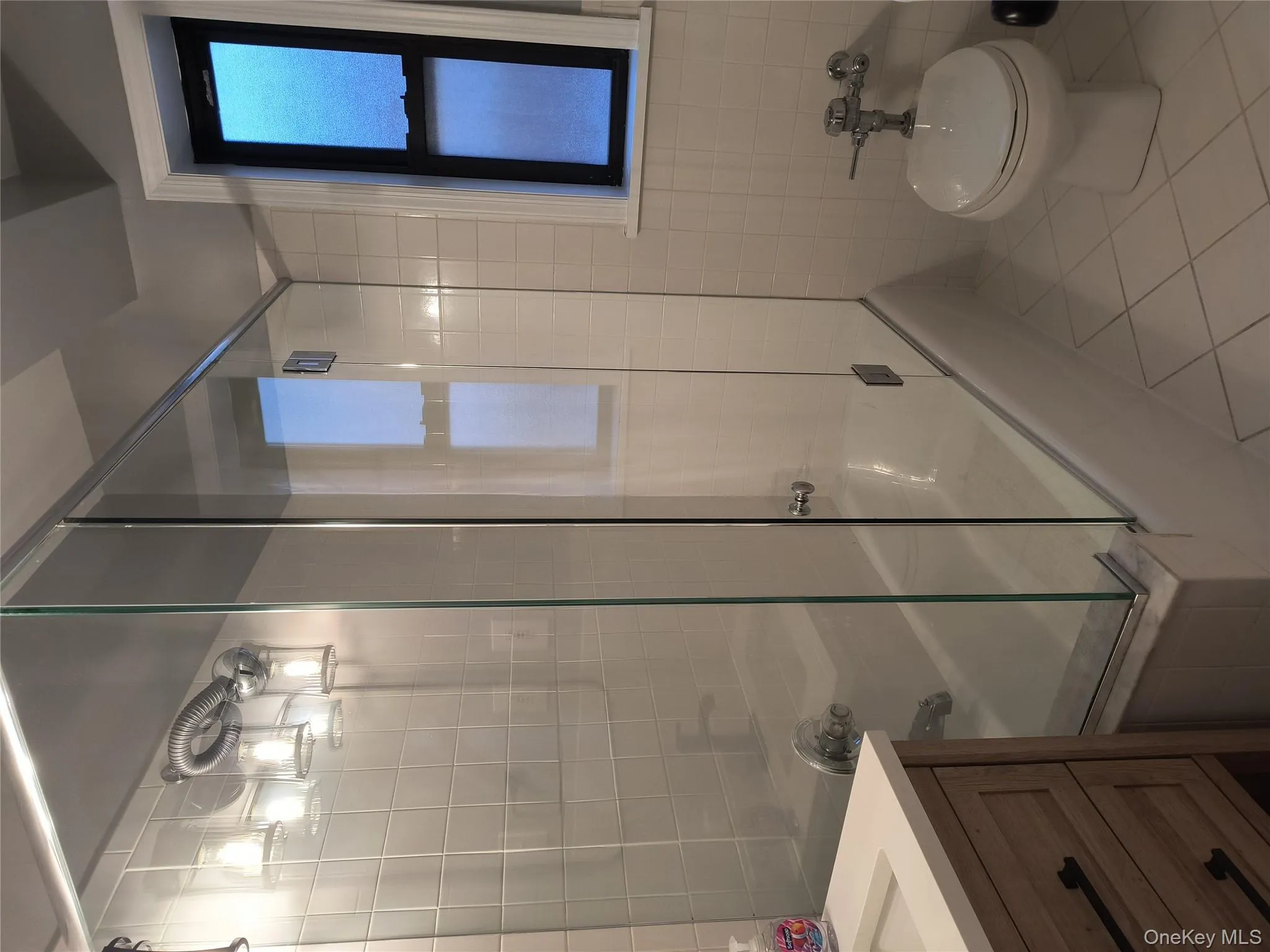 Bathroom featuring enclosed tub / shower combo, tile patterned floors, vanity, and tile walls Bathroom featuring enclosed tub / shower combo, tile patterned floors, vanity, and tile walls