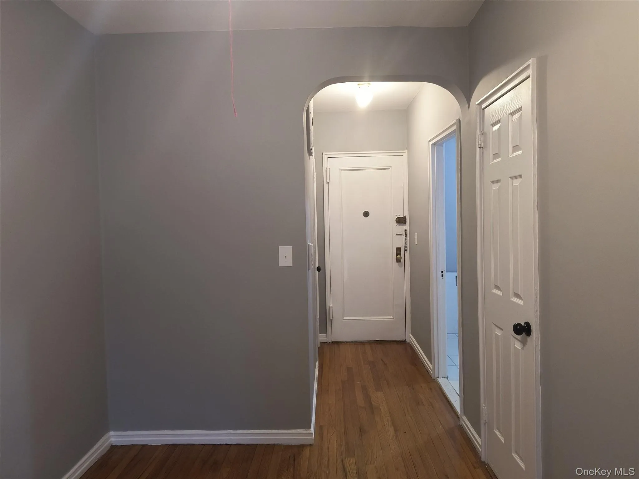 Hall featuring dark wood-type flooring and arched walkways Hall featuring dark wood-type flooring and arched walkways