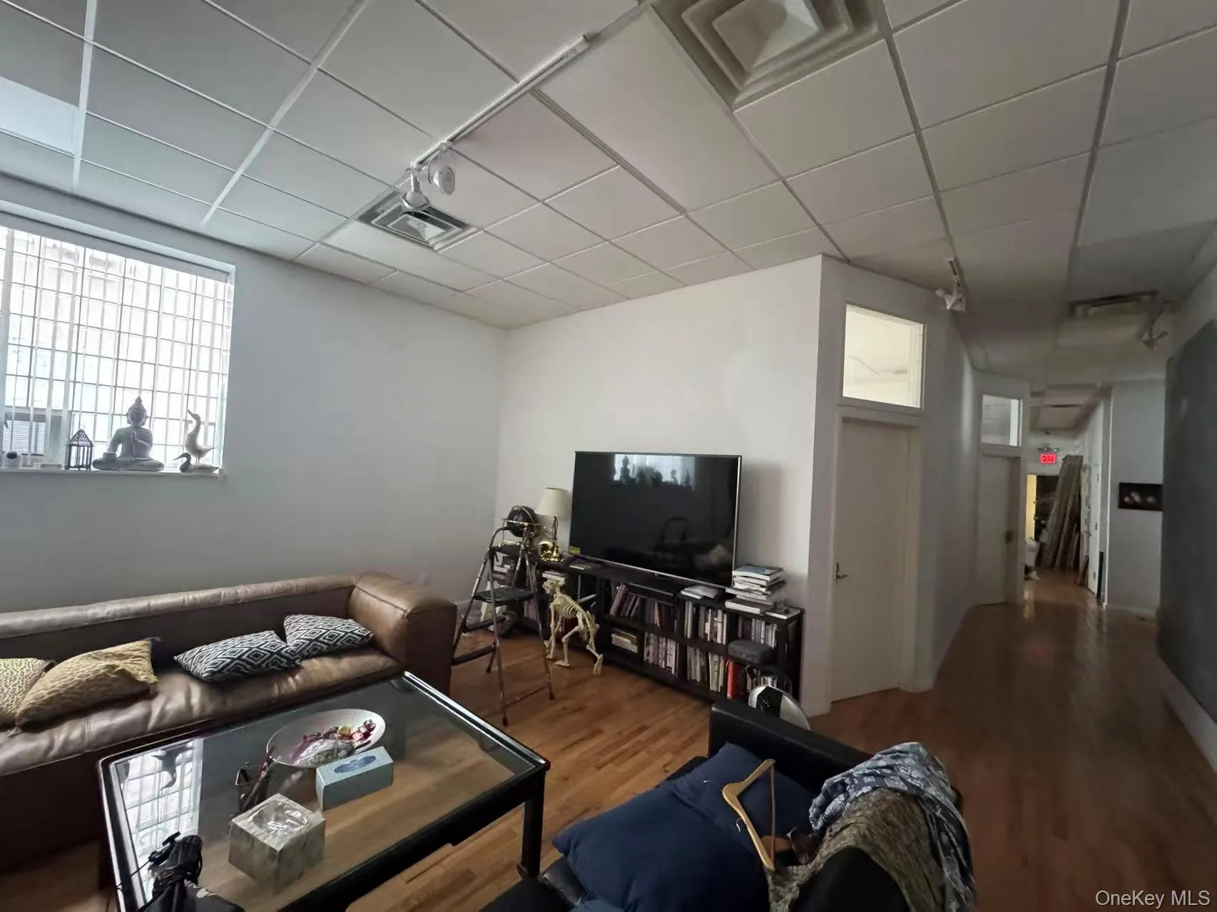 Living room with wood finished floors and a paneled ceiling Living room with wood finished floors and a paneled ceiling