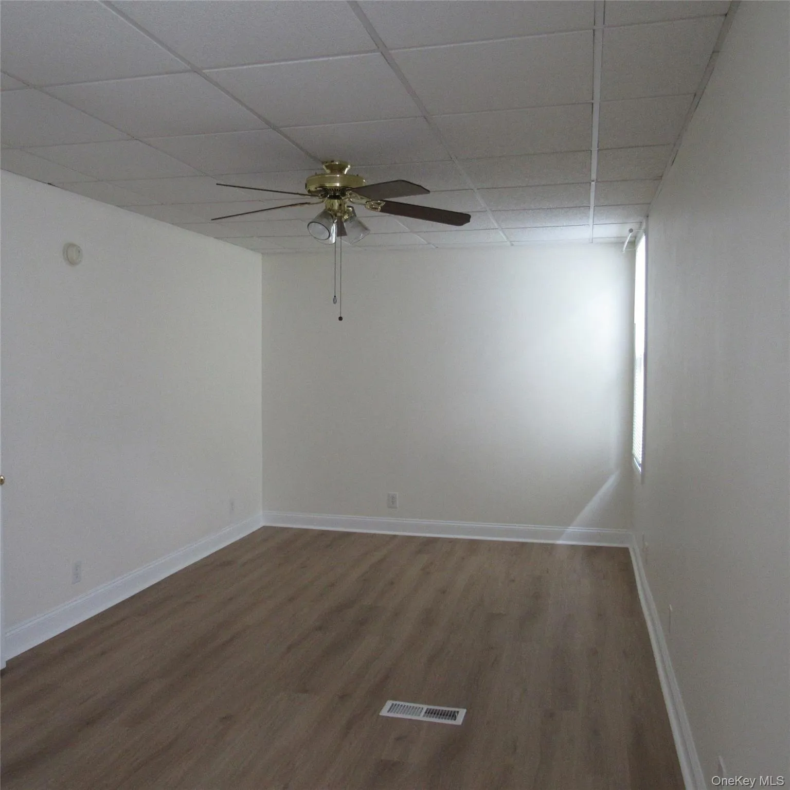 Unfurnished bedroom featuring a paneled ceiling, ceiling fan, and dark wood finished floors Unfurnished bedroom featuring a paneled ceiling, ceiling fan, and dark wood finished floors