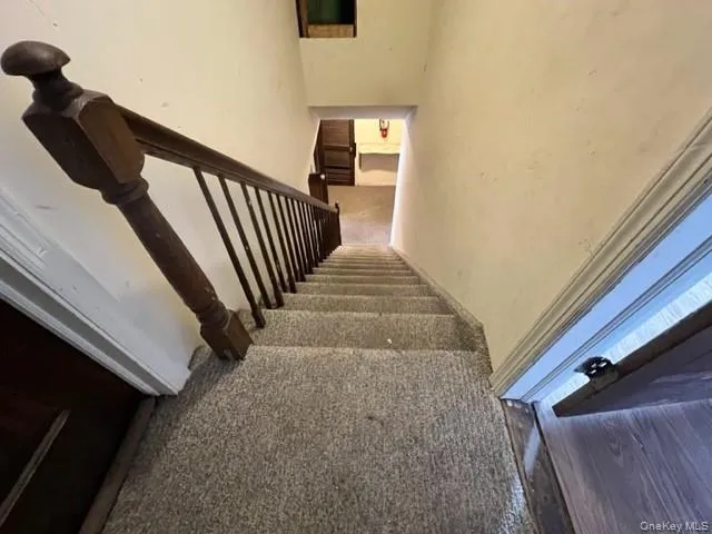 Stairway featuring carpet floors and a high ceiling Stairway featuring carpet floors and a high ceiling