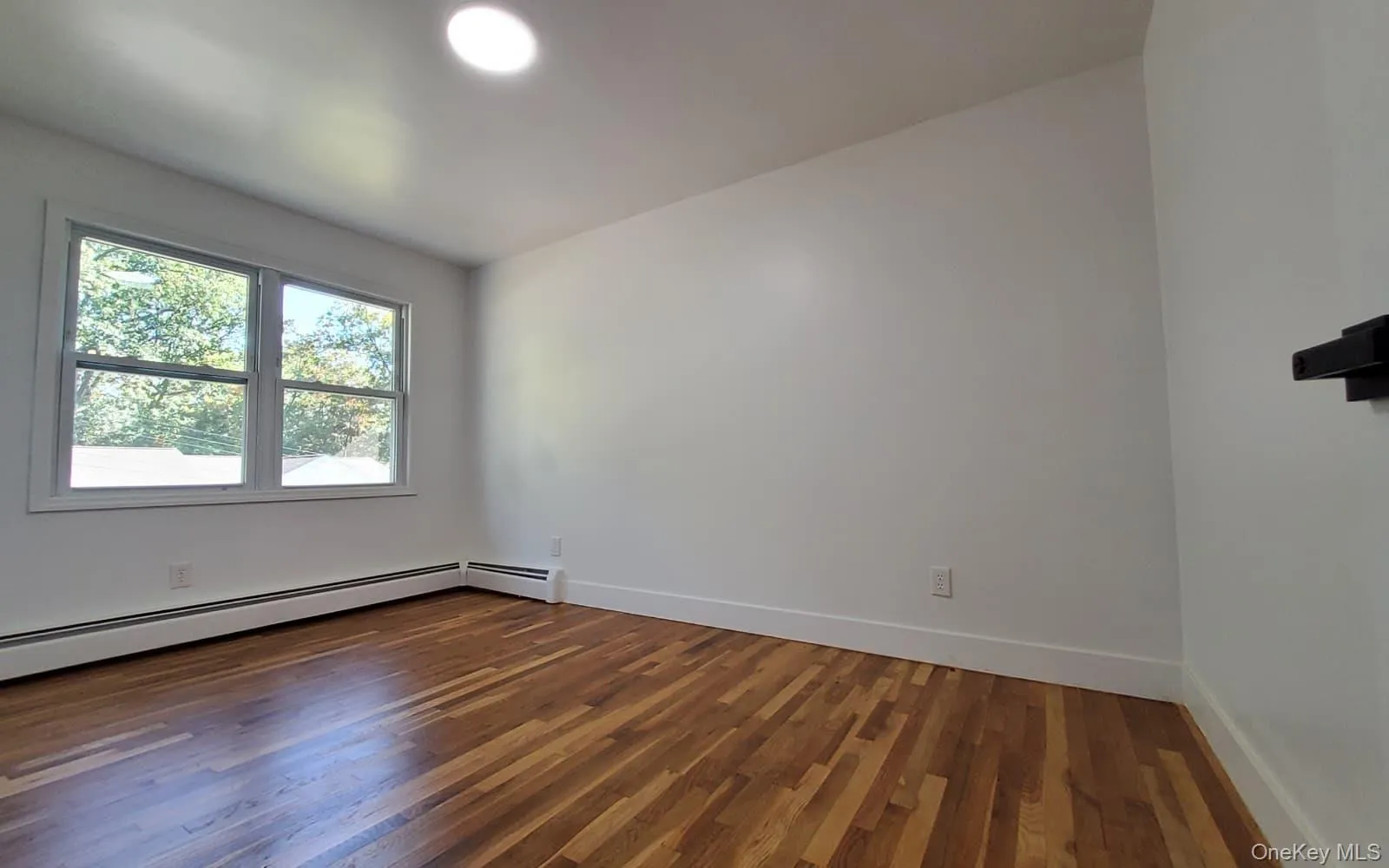 Empty room featuring dark wood finished floors and baseboards Empty room featuring dark wood finished floors and baseboards