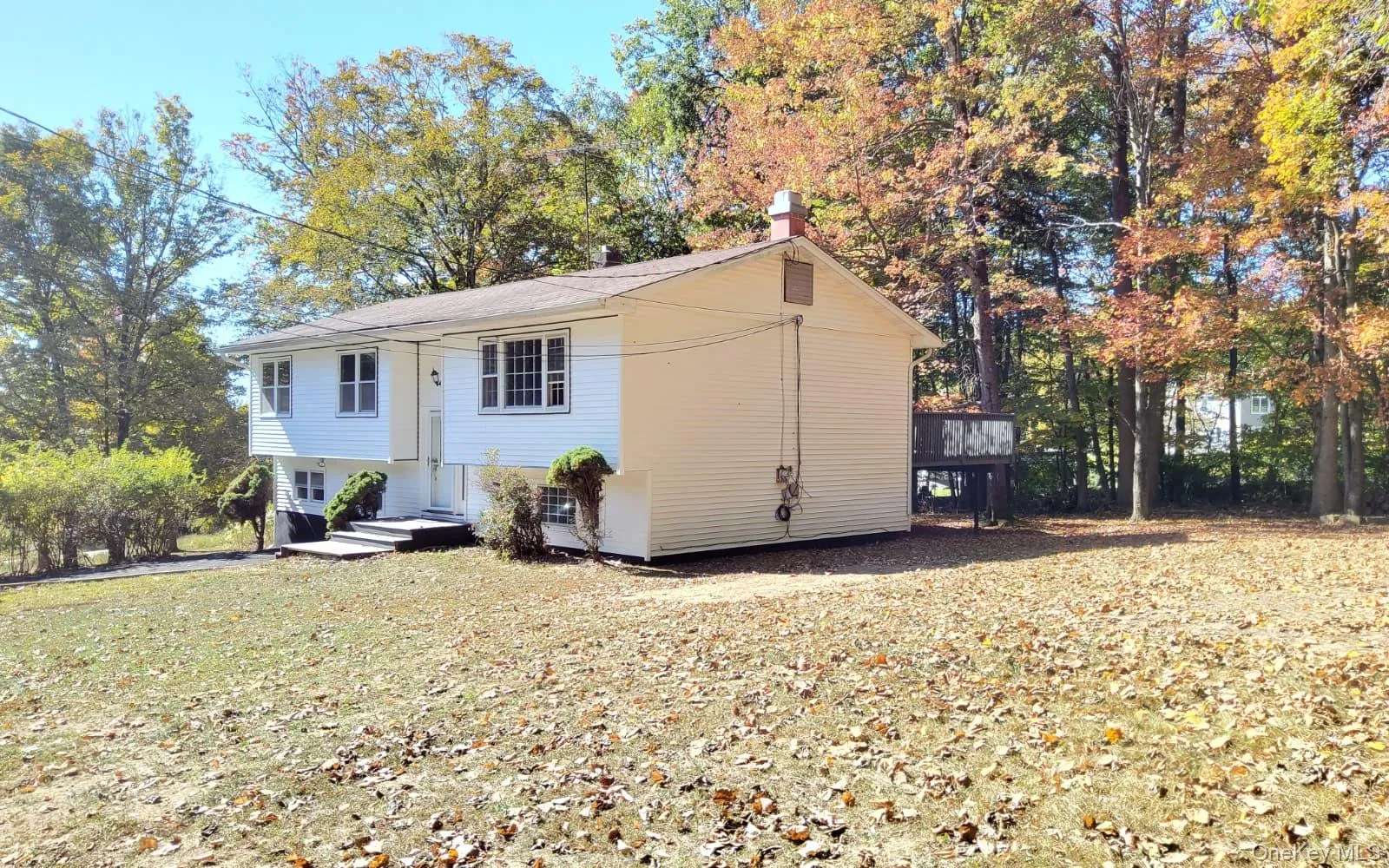 View of front of home with a chimney and a deck View of front of home with a chimney and a deck