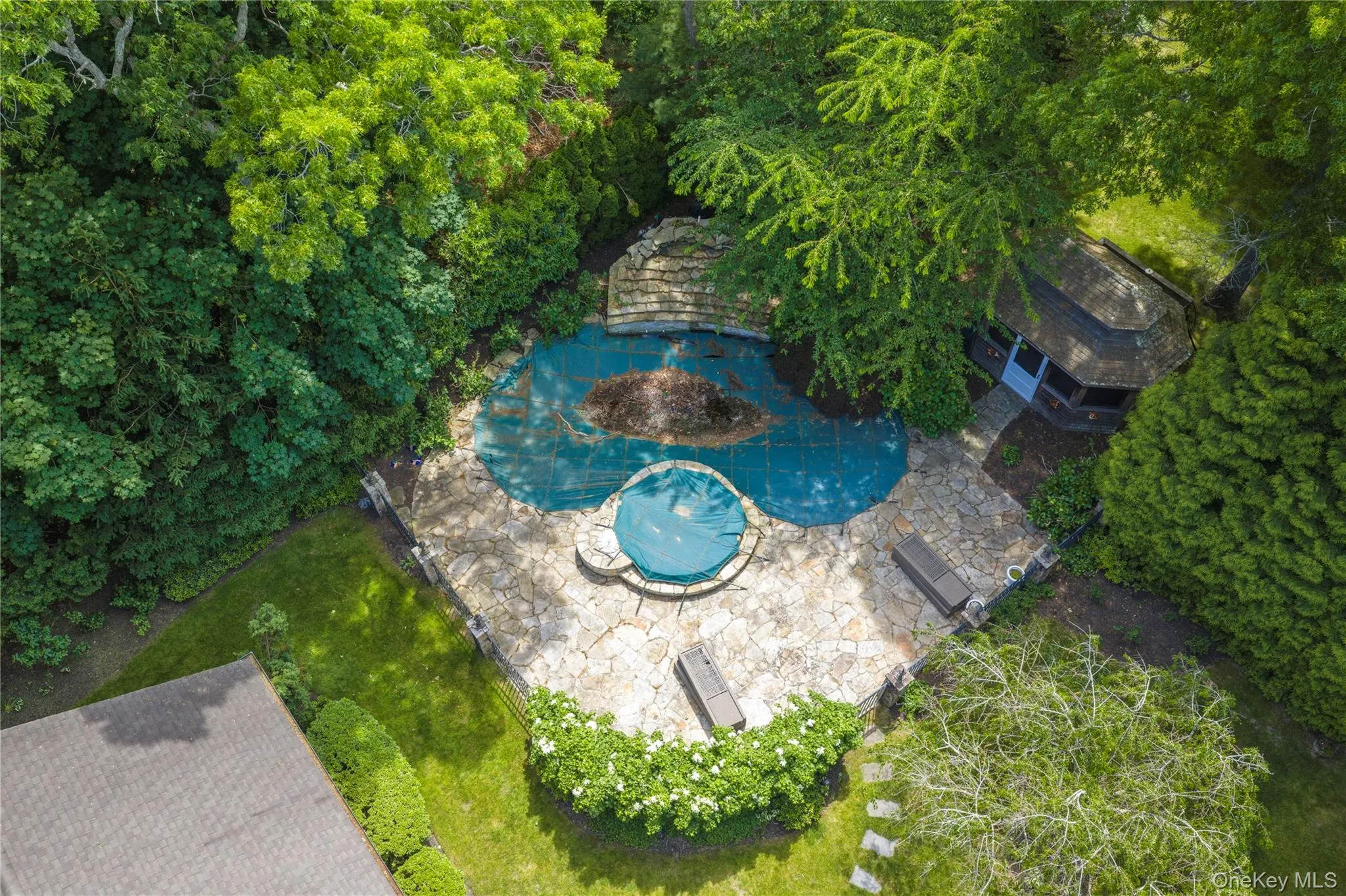 Custom pool and waterfall feature with a gated bluestone patio and lounge deck. Custom pool and waterfall feature with a gated bluestone patio and lounge deck.