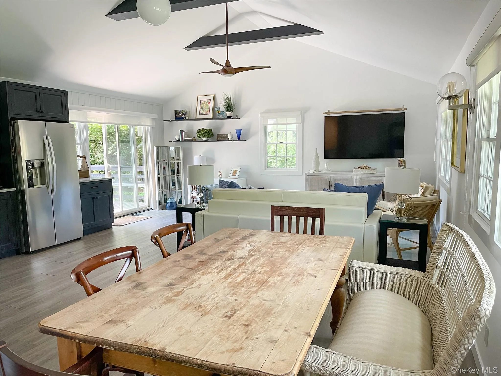 Dining space with ceiling fan, vaulted ceiling, and light wood-type flooring Dining space with ceiling fan, vaulted ceiling, and light wood-type flooring