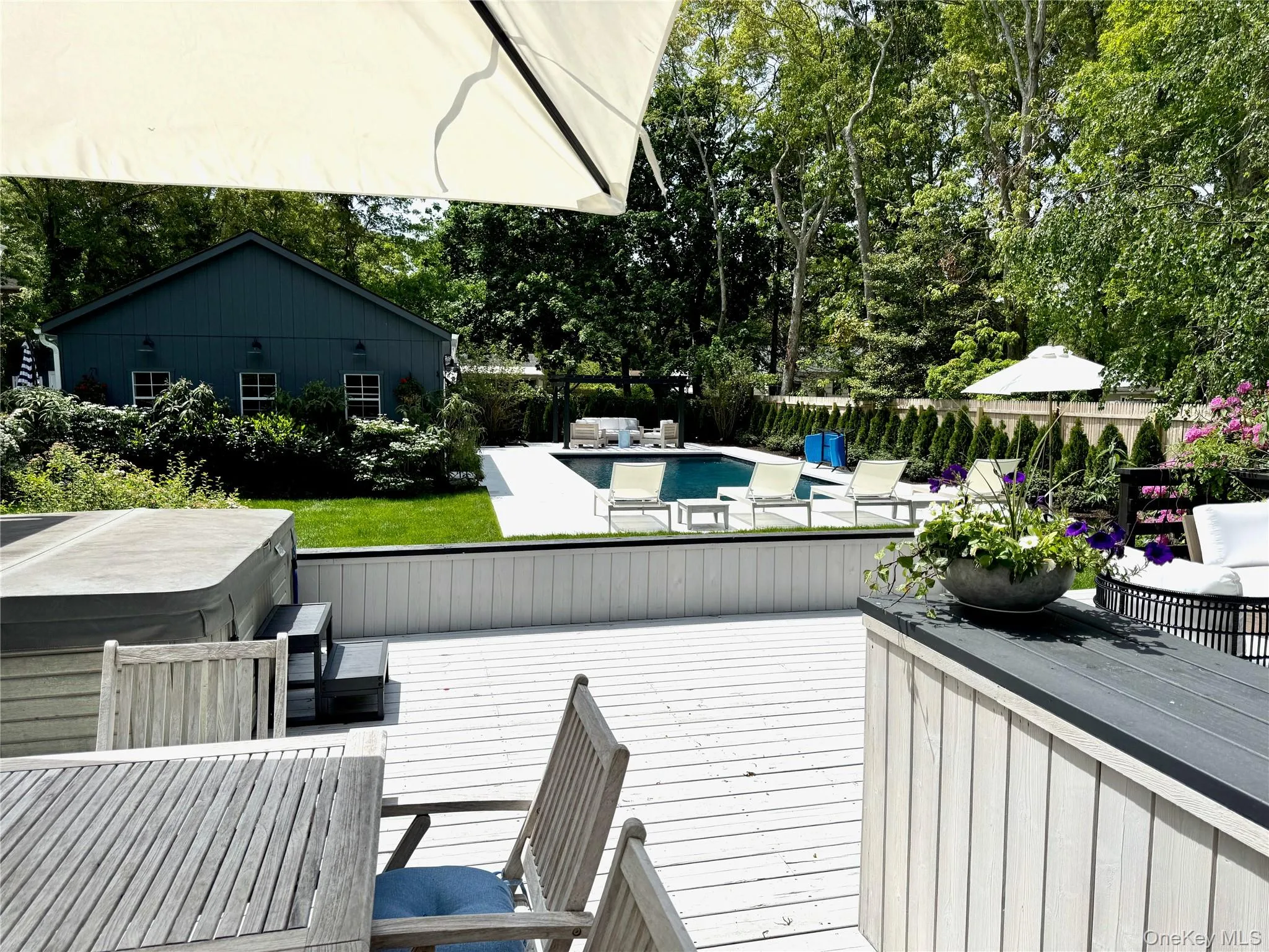 Wooden deck featuring view of scattered trees, a hot tub, outdoor dining space, and an outdoor hangout area Wooden deck featuring view of scattered trees, a hot tub, outdoor dining space, and an outdoor hangout area