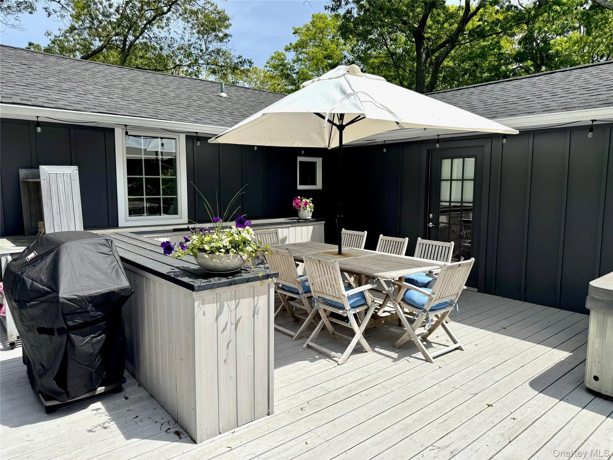 Wooden terrace featuring outdoor dining space and a grill Wooden terrace featuring outdoor dining space and a grill