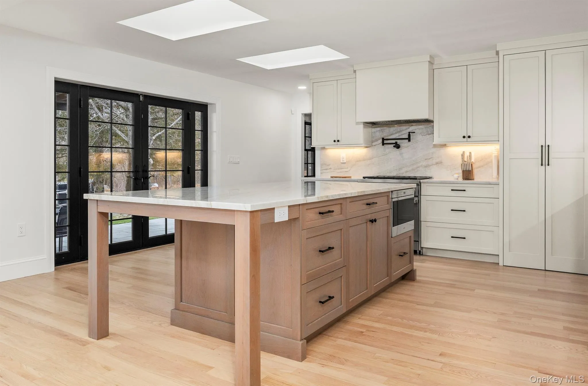 Kitchen featuring skylights, French doors to covered patio. Kitchen featuring skylights, French doors to covered patio.