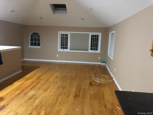Spare room featuring lofted ceiling and light wood finished floors Spare room featuring lofted ceiling and light wood finished floors
