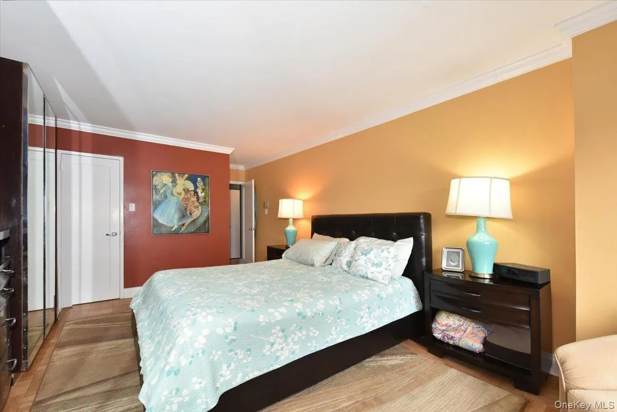 Bedroom with ornamental molding, a closet, and wood finished floors Bedroom with ornamental molding, a closet, and wood finished floors