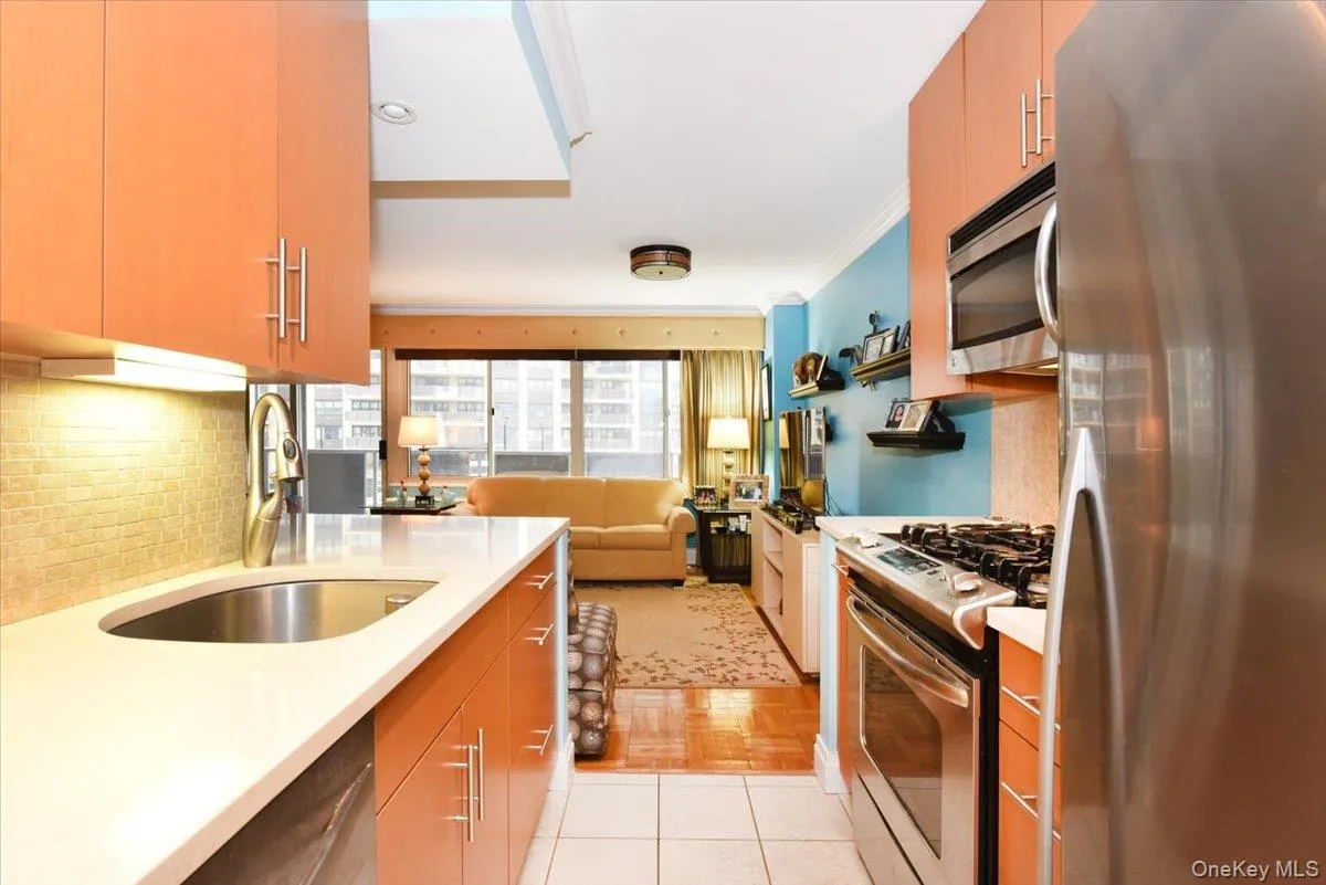 Kitchen with appliances with stainless steel finishes, open floor plan, light tile patterned floors, tasteful backsplash, and modern cabinets Kitchen with appliances with stainless steel finishes, open floor plan, light tile patterned floors, tasteful backsplash, and modern cabinets