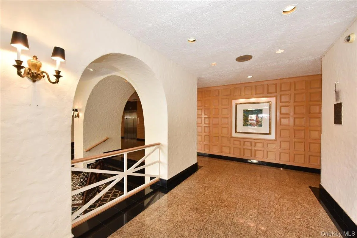 Corridor with granite tiled floors, recessed lighting, a textured ceiling, and an upstairs landing Corridor with granite tiled floors, recessed lighting, a textured ceiling, and an upstairs landing