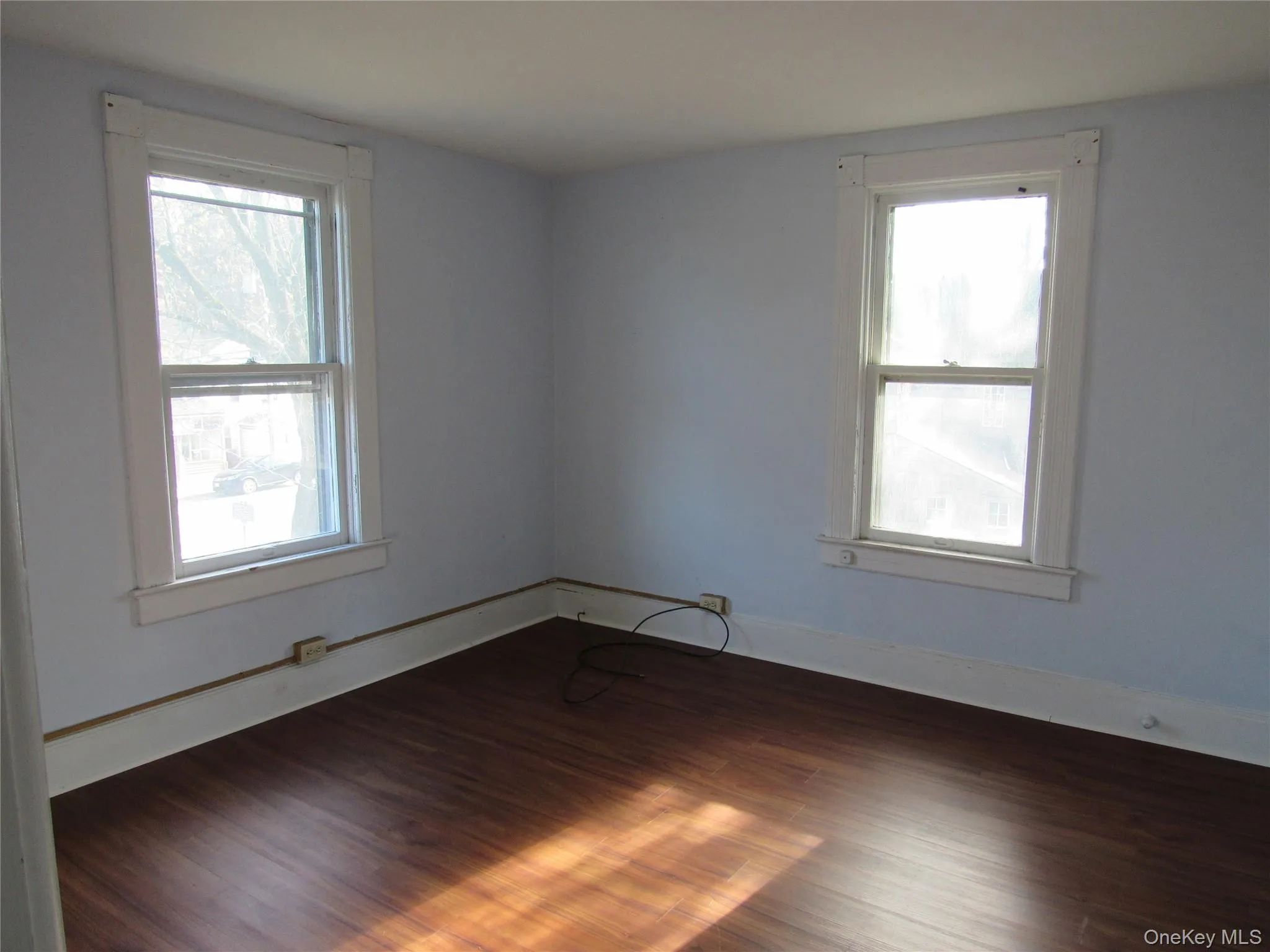 Bedroom 1 with dark wood-type flooring and baseboards Bedroom 1 with dark wood-type flooring and baseboards