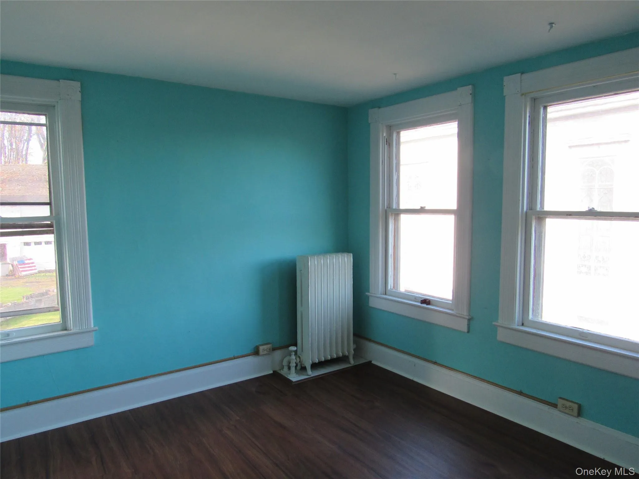 Bedroom #3 with dark wood-type flooring and radiator heating unit Bedroom #3 with dark wood-type flooring and radiator heating unit