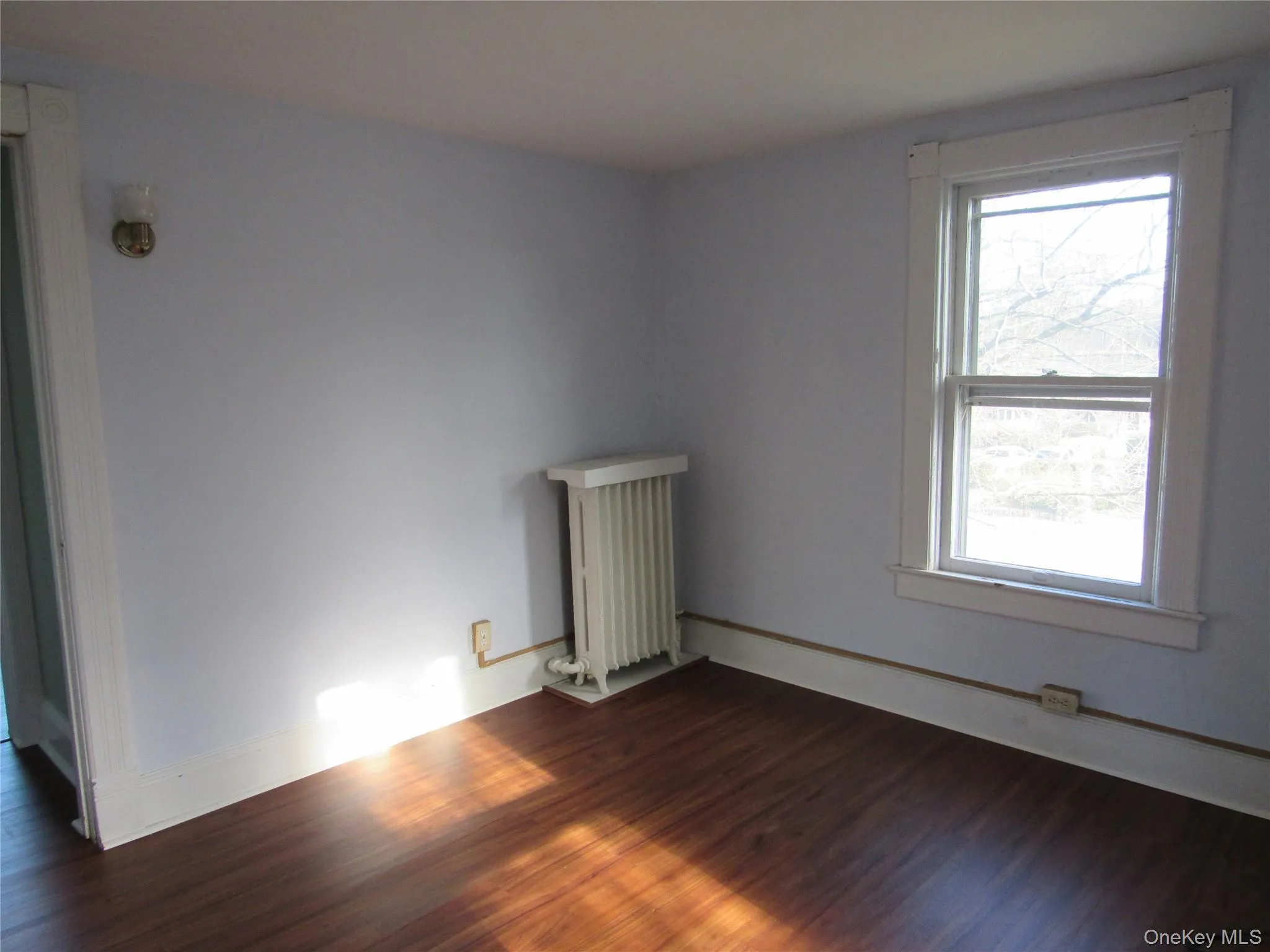 Bedroom #1 featuring dark wood finished floors and radiator heating unit Bedroom #1 featuring dark wood finished floors and radiator heating unit