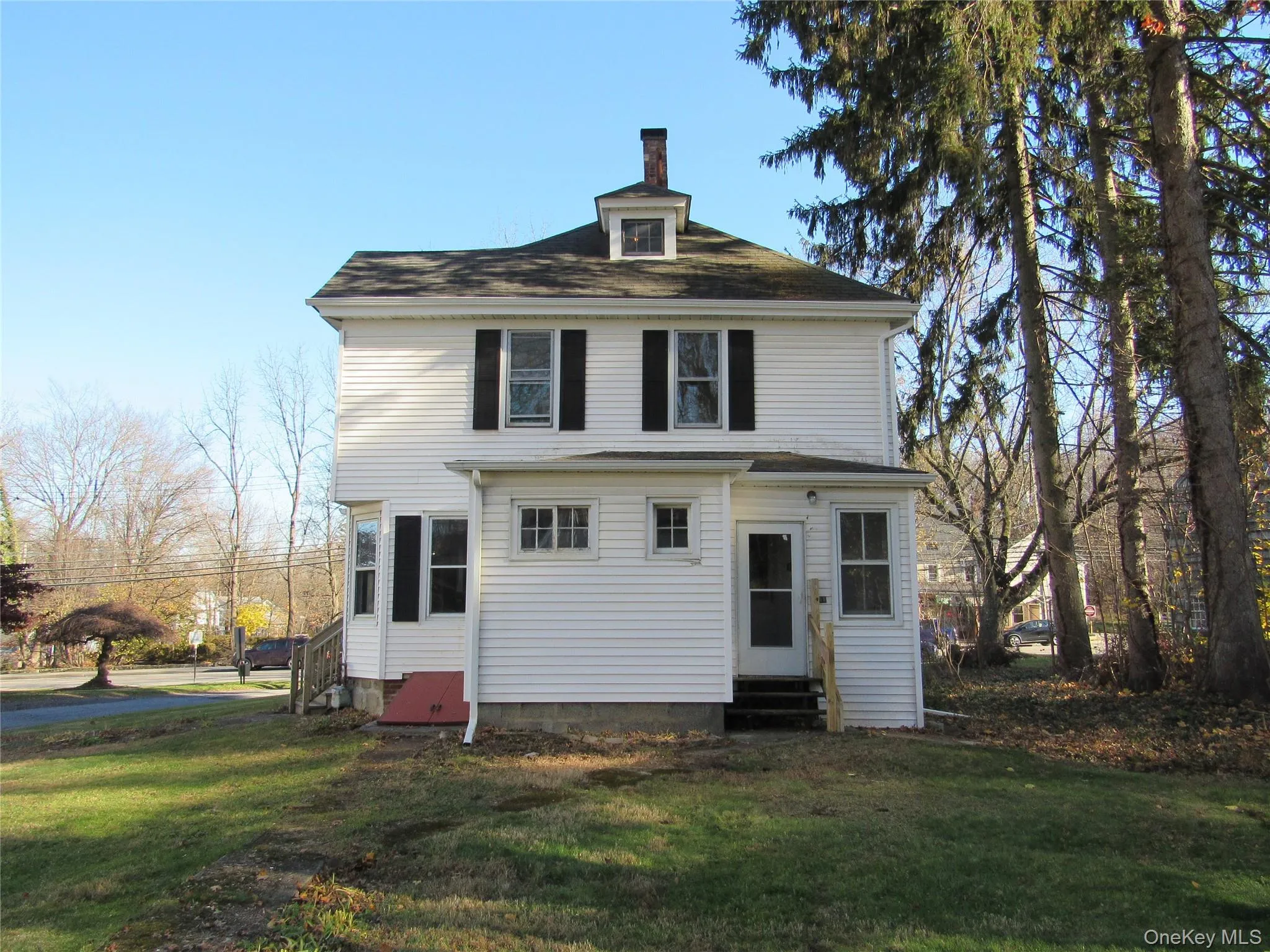 Rear view of house featuring entry steps, a yard, and a chimney Rear view of house featuring entry steps, a yard, and a chimney