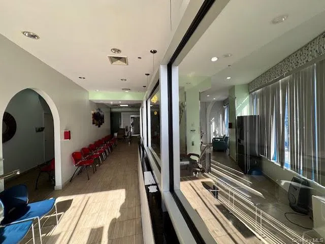 Hall featuring arched walkways, recessed lighting, and light wood finished floors Hall featuring arched walkways, recessed lighting, and light wood finished floors