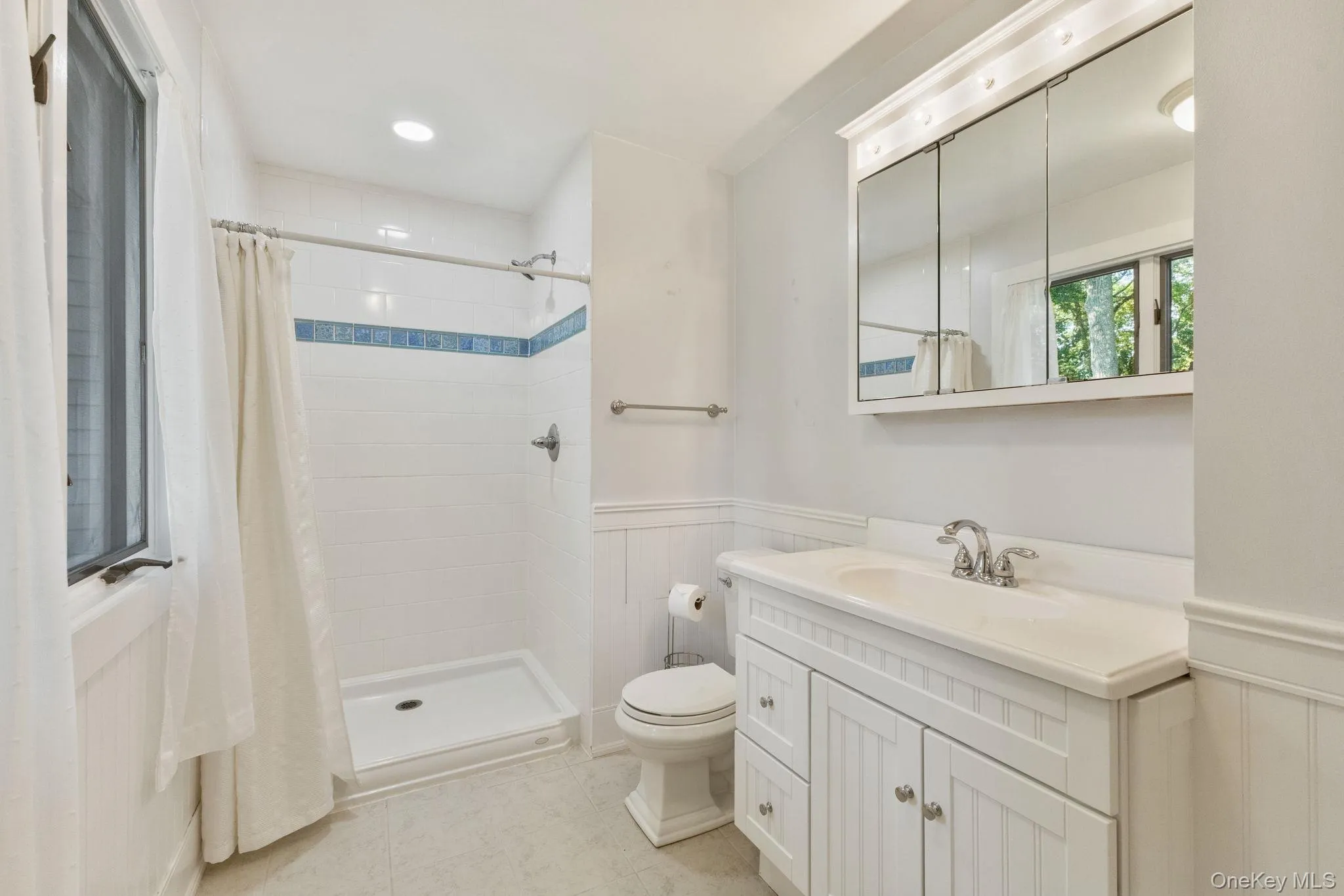 Updated primary bathroom with clean finishes, a walk-in shower, and elegant wainscoting. Updated primary bathroom with clean finishes, a walk-in shower, and elegant wainscoting.