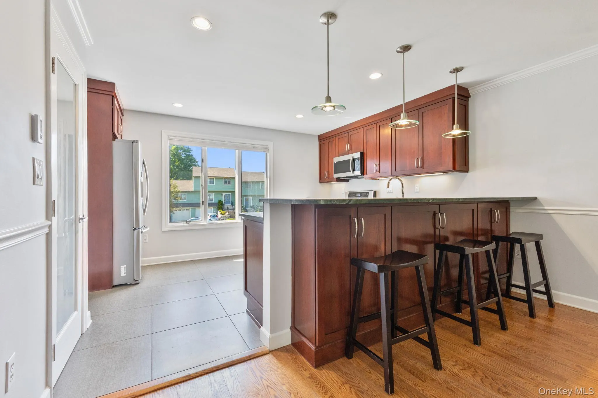 Oversized window fills the space with natural light, plus a breakfast bar that opens to the dining area. Oversized window fills the space with natural light, plus a breakfast bar that opens to the dining area.