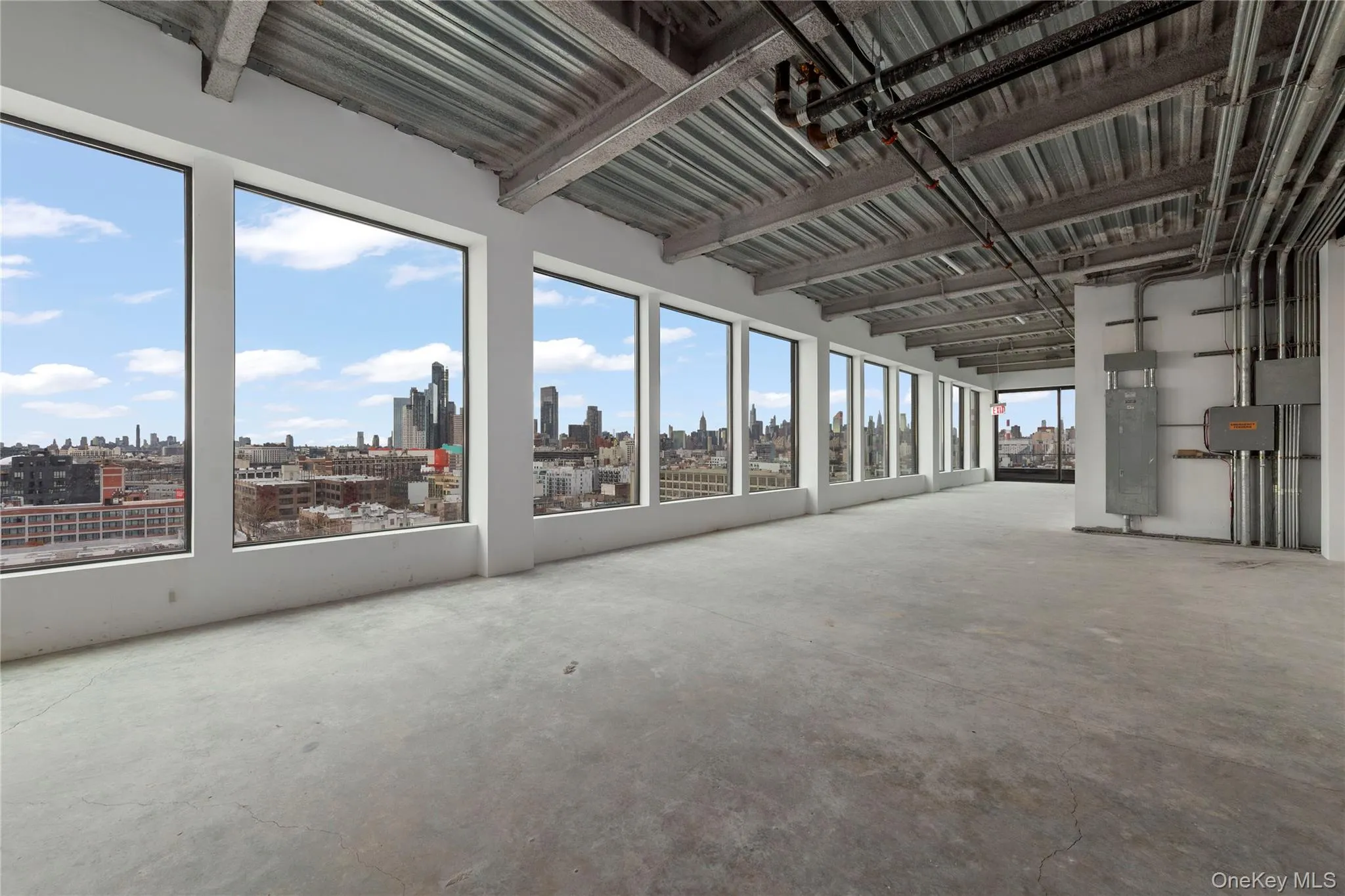 Unfurnished sunroom featuring unfinished concrete floors and a view of skyline Unfurnished sunroom featuring unfinished concrete floors and a view of skyline