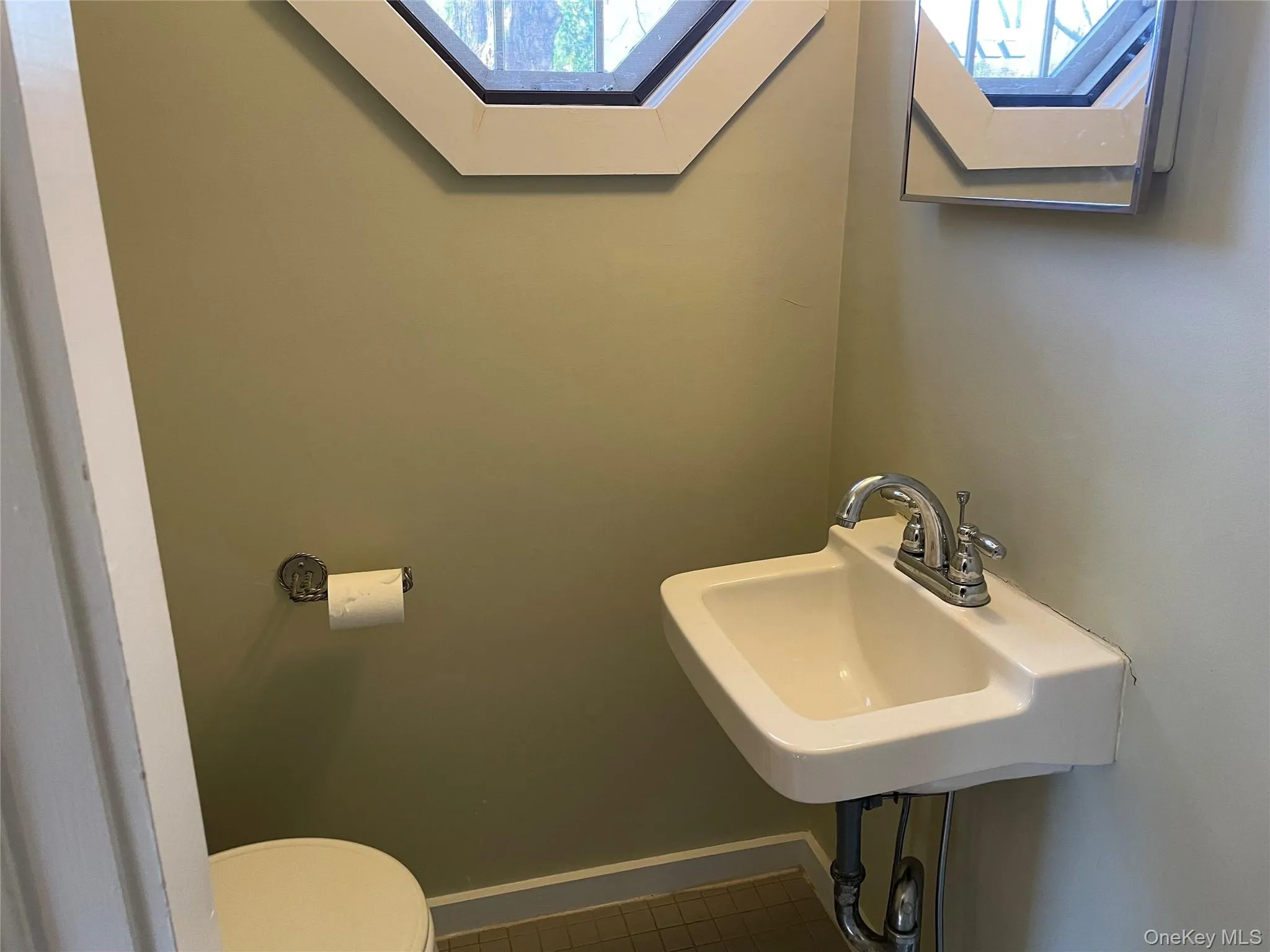 Bathroom with a skylight and dark tile patterned floors Bathroom with a skylight and dark tile patterned floors