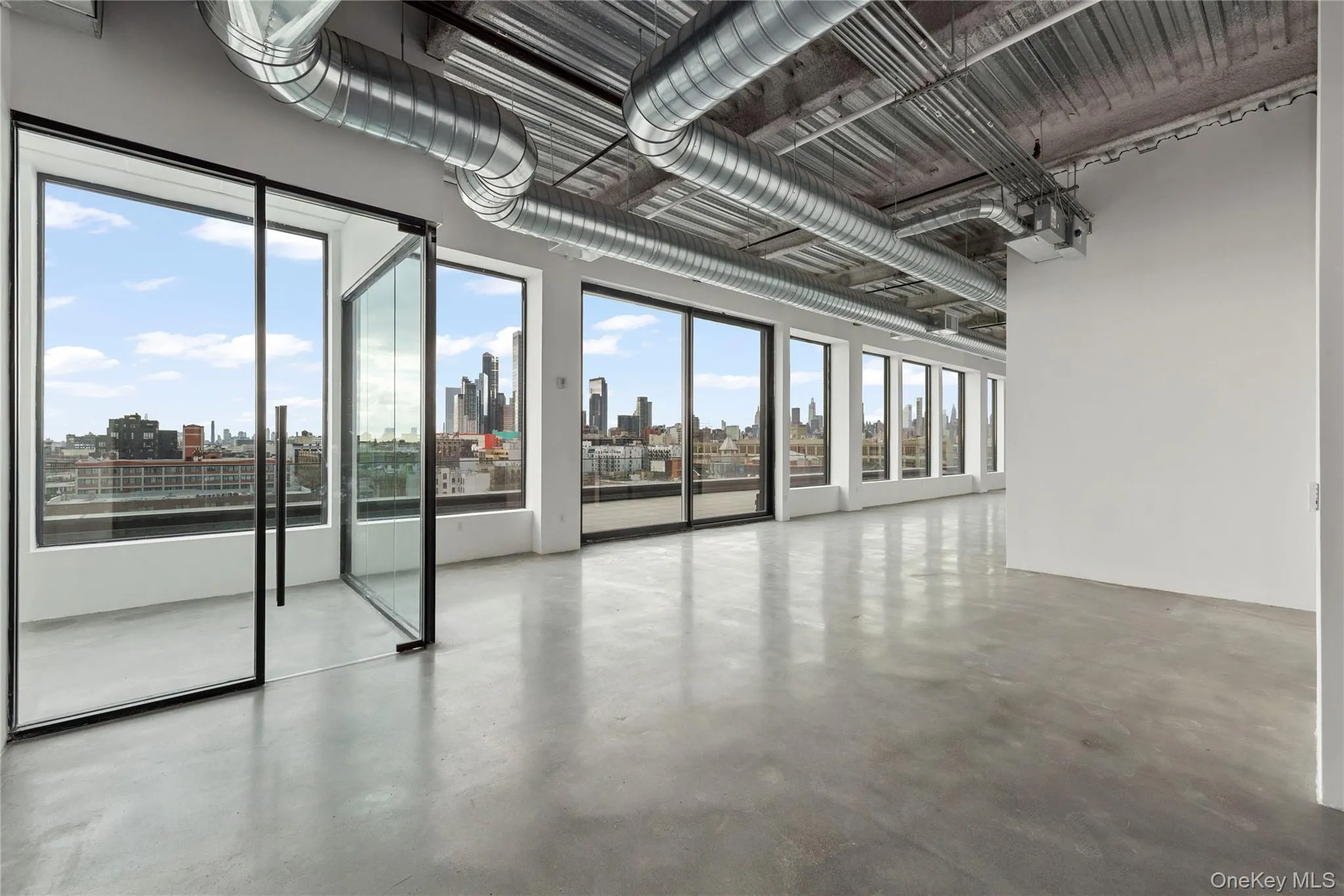 Spare room featuring finished concrete flooring and a skyline view Spare room featuring finished concrete flooring and a skyline view