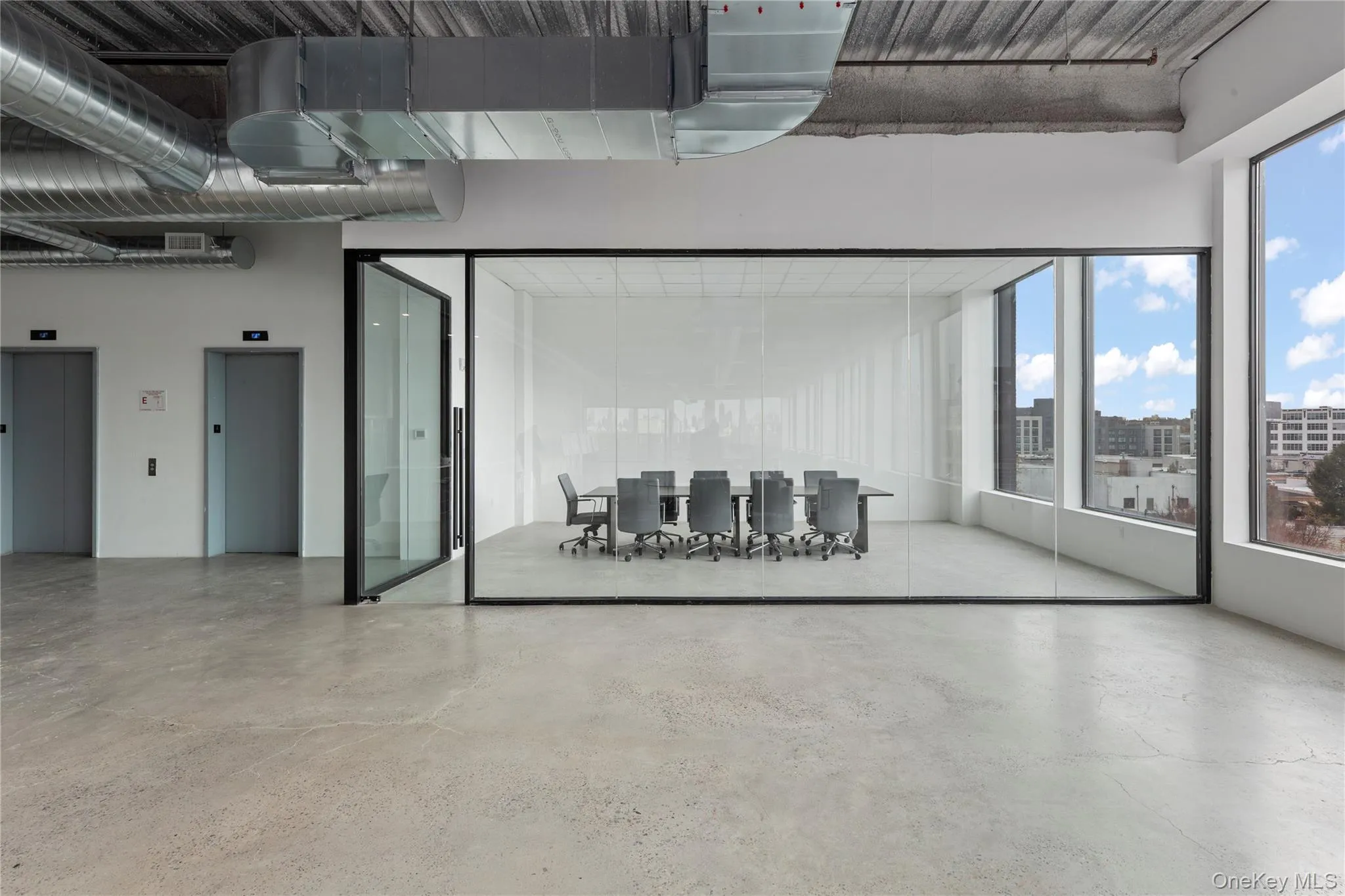 Unfurnished living room with elevator, concrete floors, and a city view Unfurnished living room with elevator, concrete floors, and a city view
